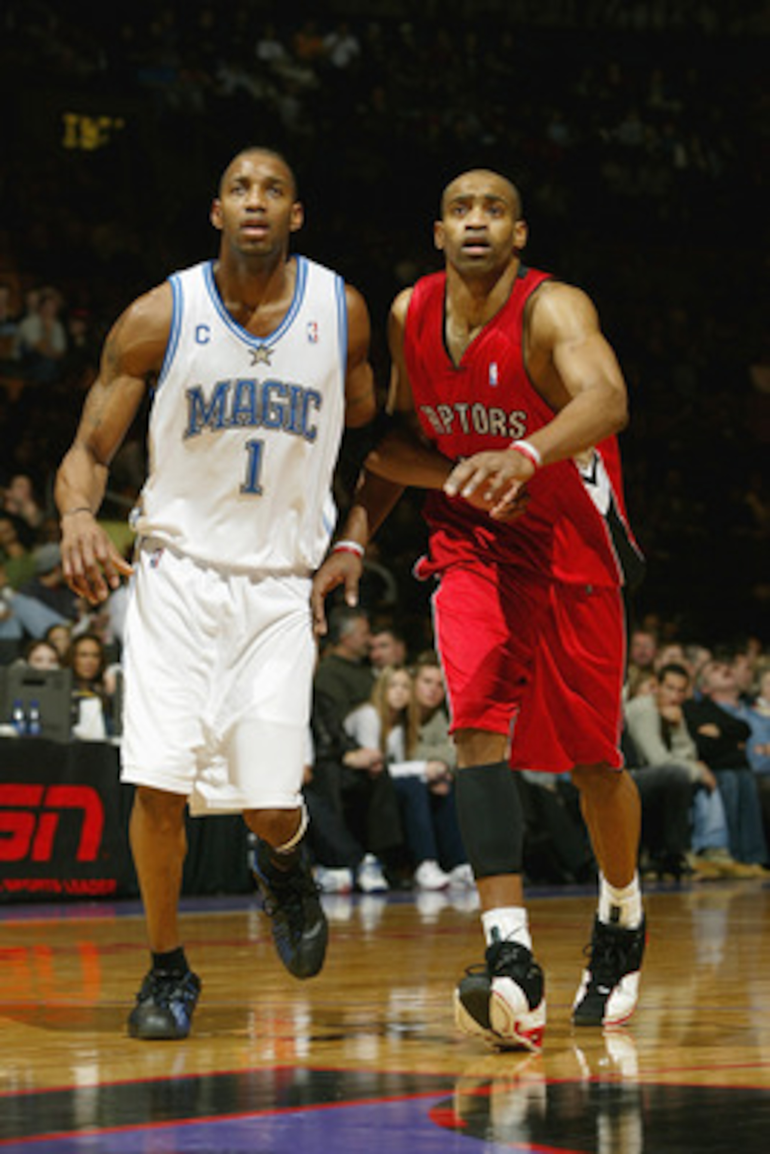 TORONTO - DECEMBER 21:  Tracy McGrady #1 of the Orlando Magic stands next to Vince Carter #15 of the Toronto Raptors during the game on December 21, 2003 at the Air Canada Centre in Toronto, Canada.  McGrady and Carter are cousins. The Magic won 104-93.