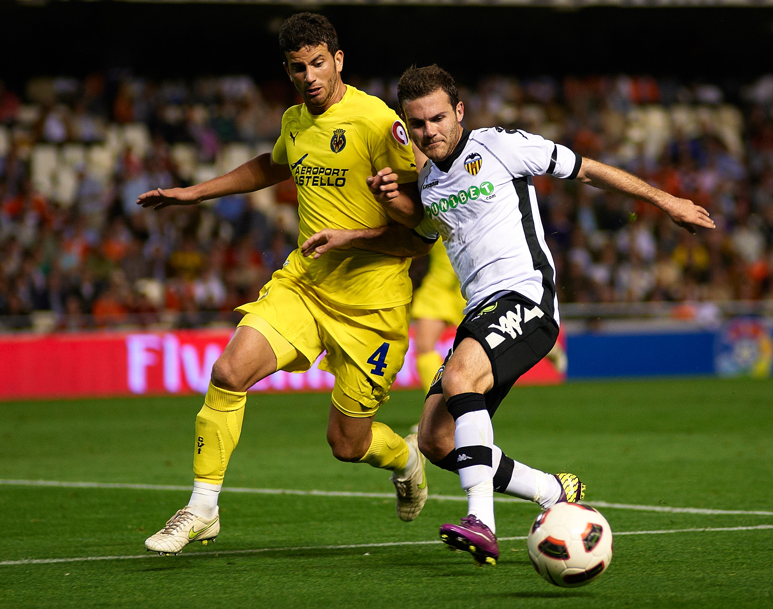 VALENCIA, VALENCIA - APRIL 10: Juan Mata (R) of Valencia duels for the ball with Mateo Musacchio of Villarreal during the La Liga match between Valencia and Villarreal at Estadio Mestalla on April 10, 2011 in Valencia, Spain.  (Photo by Manuel Queimadelos