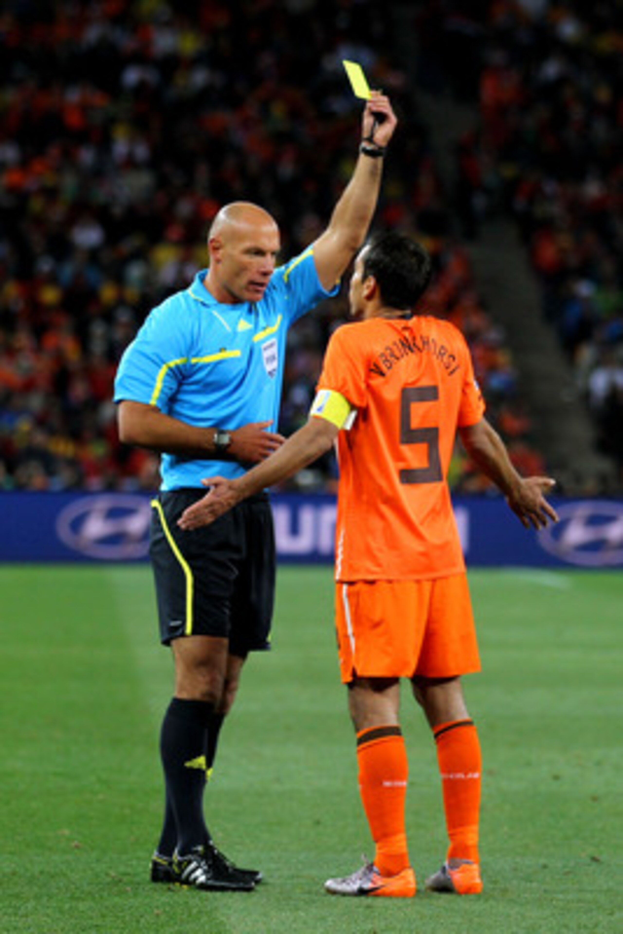 JOHANNESBURG, SOUTH AFRICA - JULY 11:  Referee Howard Webb issues Giovanni Van Bronckhorst of the Netherlands a yellow card during the 2010 FIFA World Cup South Africa Final match between Netherlands and Spain at Soccer City Stadium on July 11, 2010 in Jo