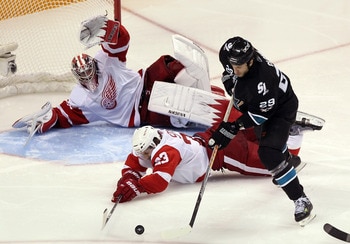 SAN JOSE, CA - APRIL 29:  Brad Stuart #23 and Jimmy Howard #35 of the Detroit Red Wings dive to stop a shot by Ryane Clowe #29 of the San Jose Sharks in Game One of the Western Conference Semifinals during the 2011 NHL Stanley Cup Playoffs at HP Pavilion