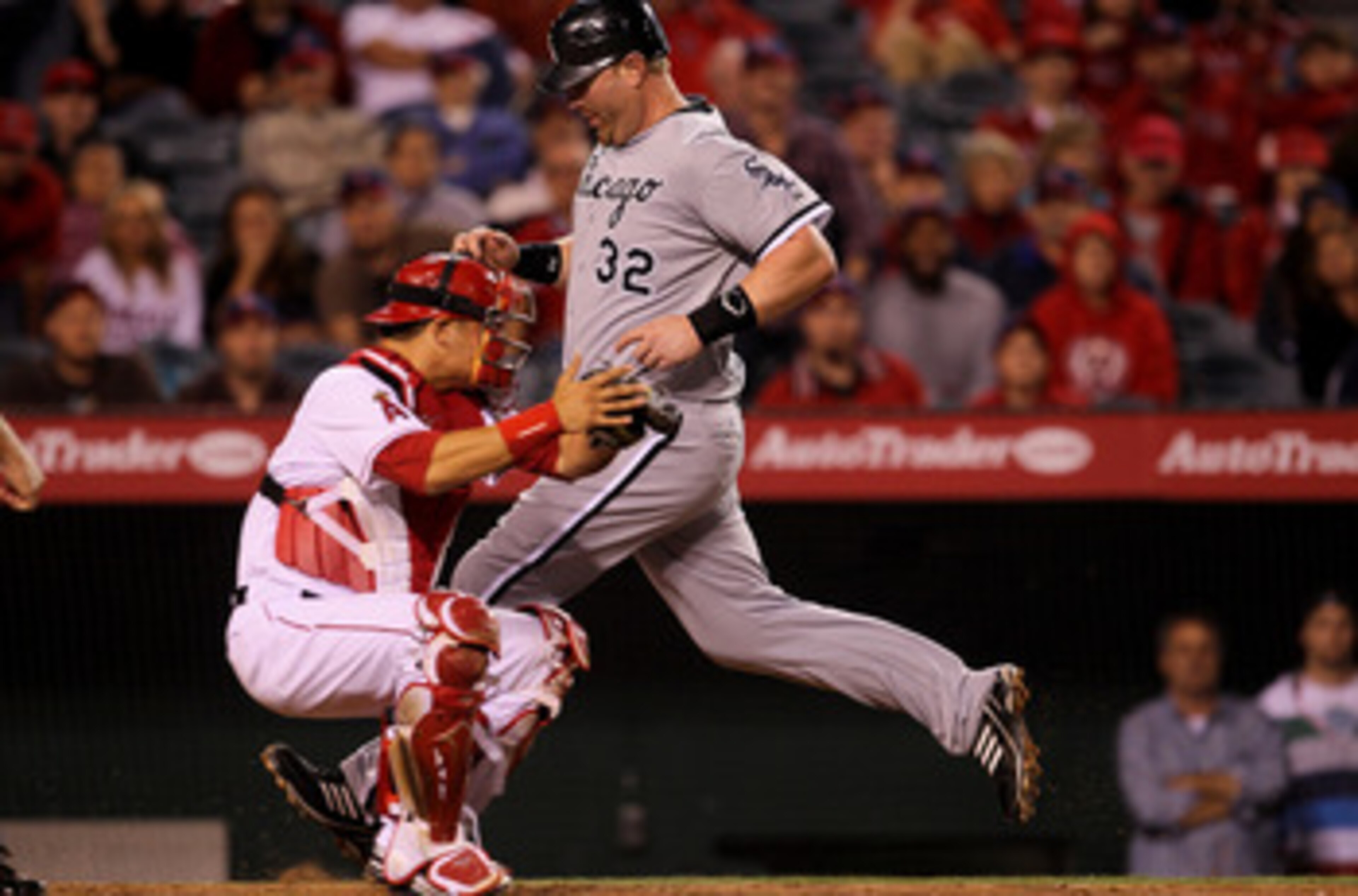 ANAHEIM, CA - MAY 11:  Adam Dunn #32 of the Chicago White Sox scores an insurance run in the tenth inning on a sacrifice fly ahead of the tag by catcher Hank Conger #16 of the Los Angeles Angels of Anaheim on May 11, 2011 at Angel Stadium in Anaheim, Cali