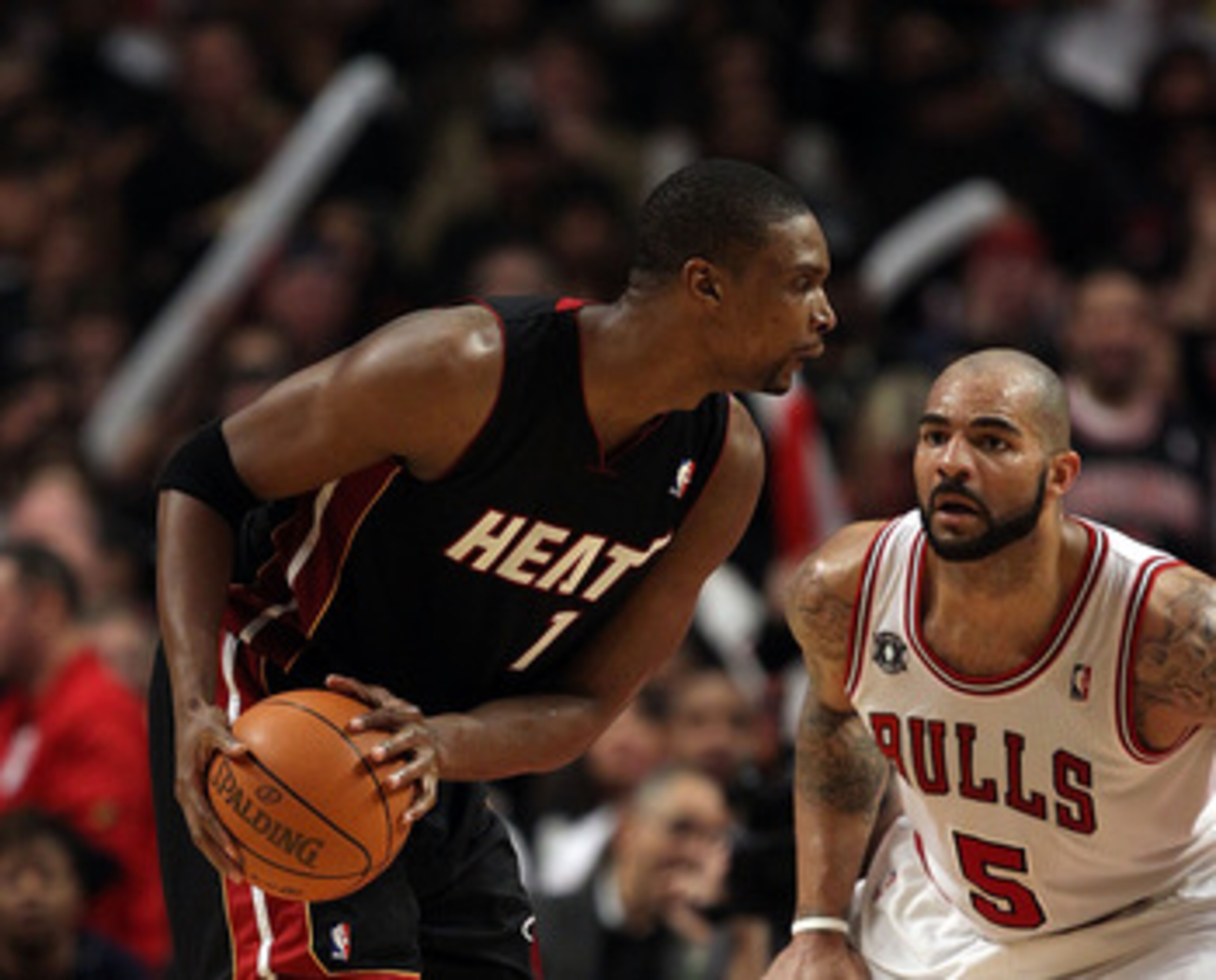 CHICAGO, IL - FEBRUARY 24: Chris Bosh #1 of the Miami Heat looks to moves against Carlos Boozer #5 of the Chicago Bulls at the United Center on February 24, 2011 in Chicago, Illinois. The Bulls defeated the Heat 93-89. NOTE TO USER: User expressly acknowl