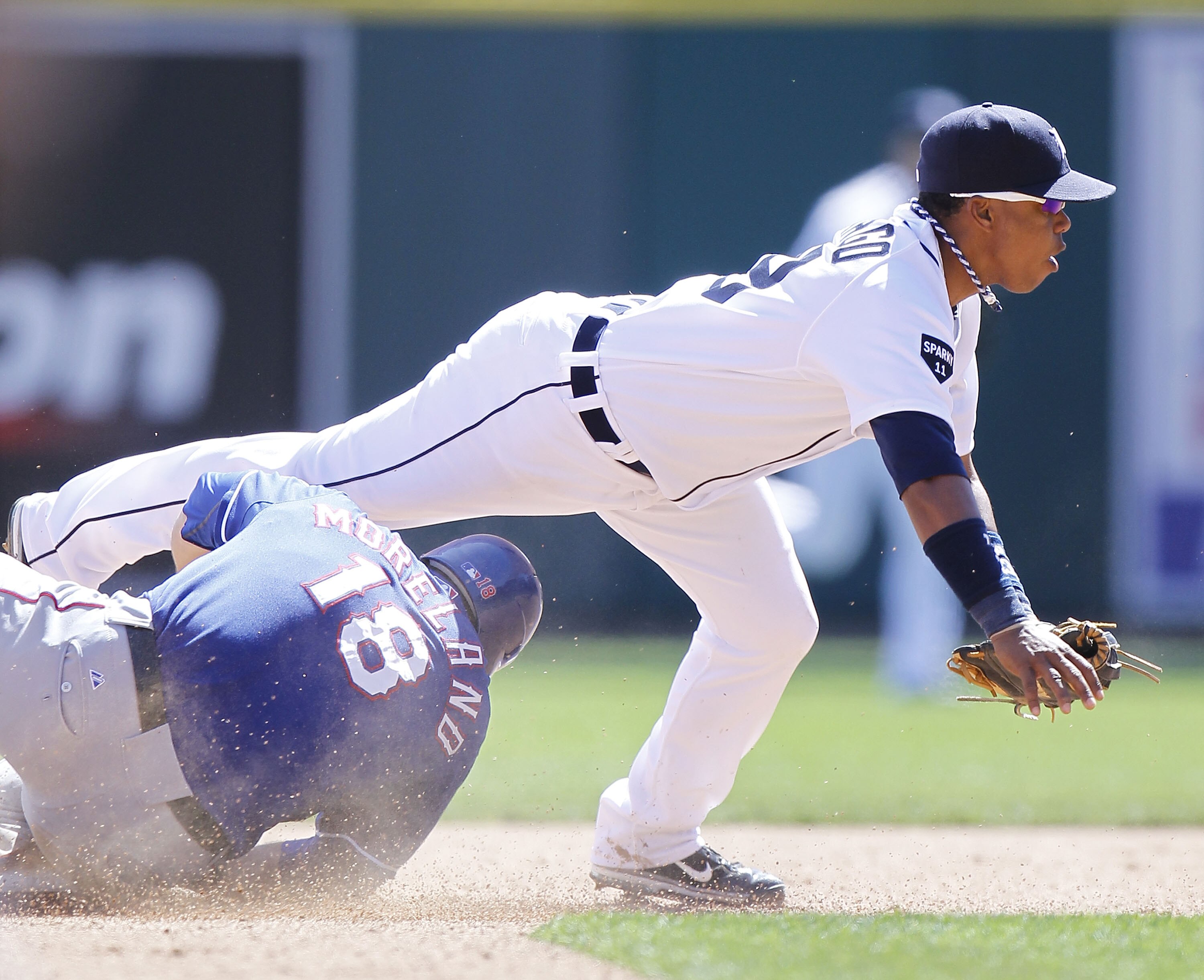 DETROIT, MI - APRIL 12:  Ramon Santiago #39 of the Detroit Tigers turns a double play over Mitch Moreland #18 of the Texas Rangers at Comerica Park on April 12, 2011 in Detroit, Michigan. Detroit won the game 5-4. (Photo by Gregory Shamus/Getty Images)