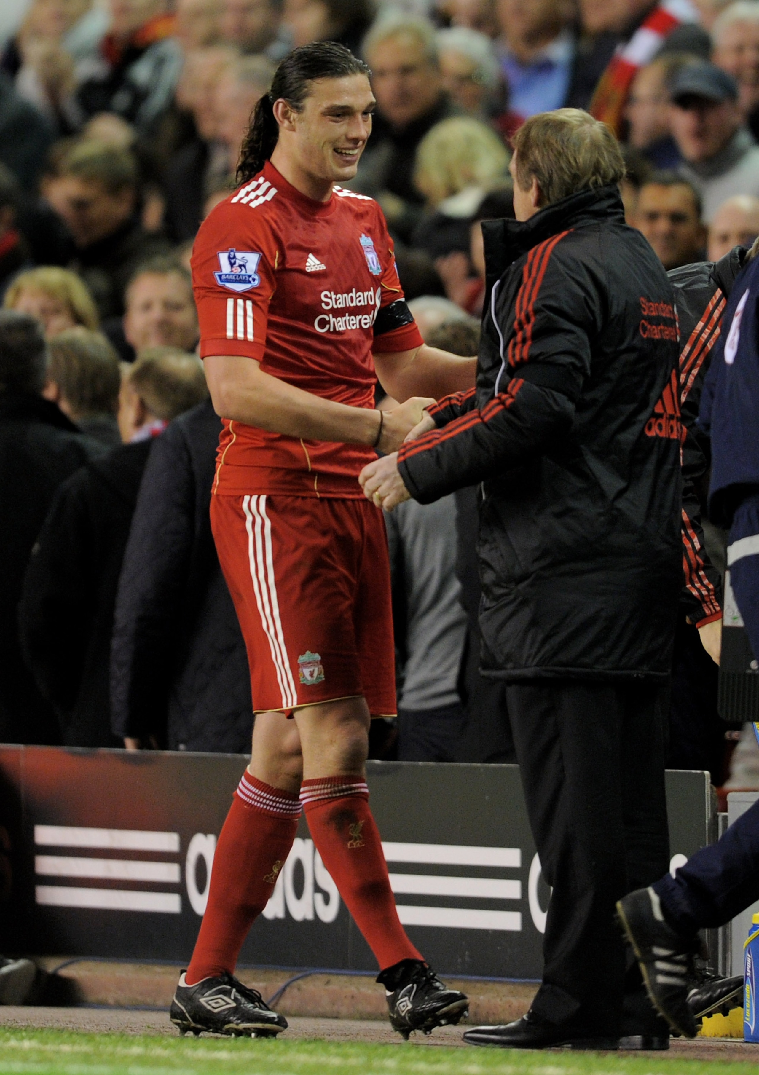 LIVERPOOL, ENGLAND - APRIL 11:  Andy Carroll of Liverpool is congratulated by his Manager Kenny Dalglish as he is substituted during the Barclays Premier League match between Liverpool and Manchester City at Anfield on April 11, 2011 in Liverpool, England