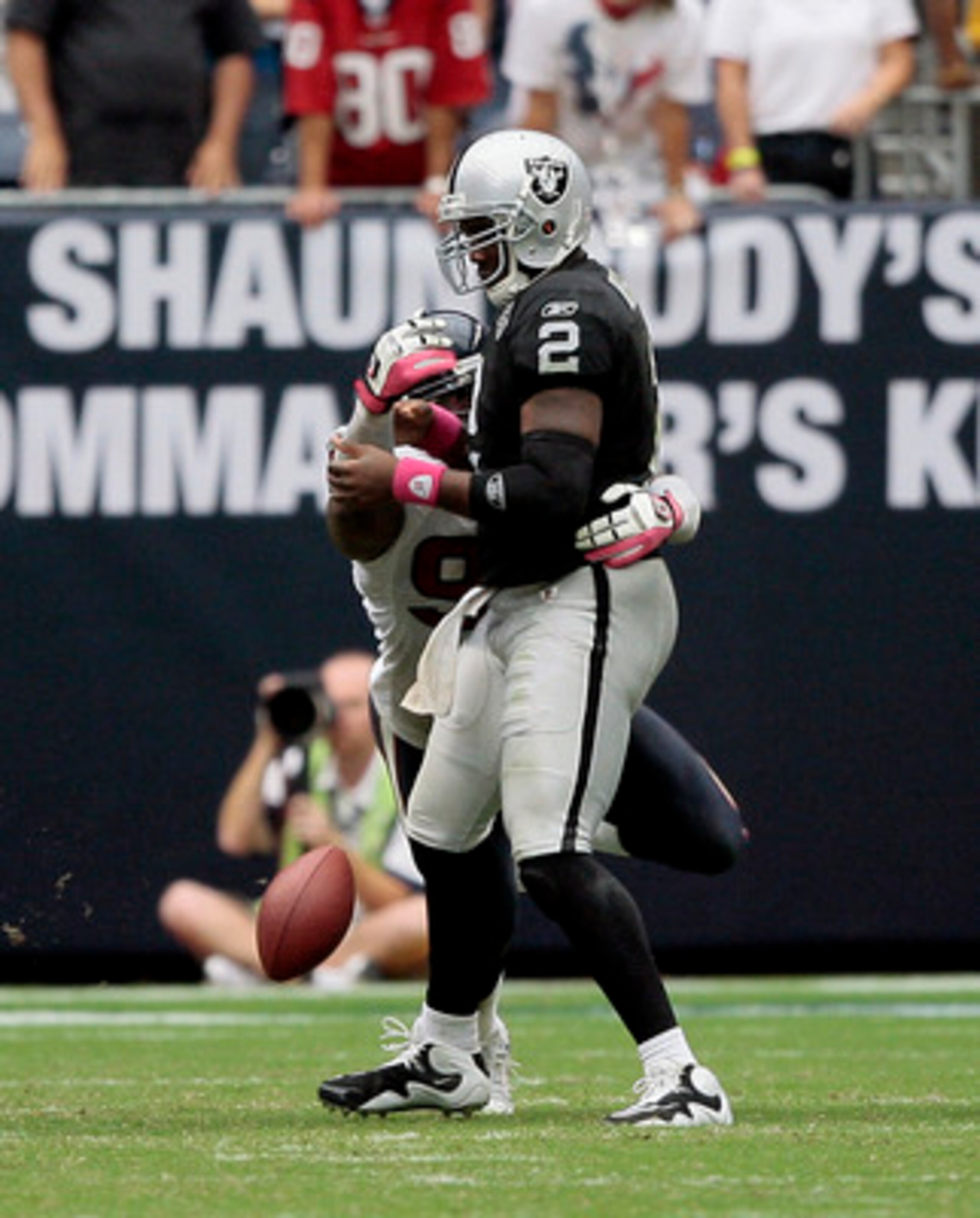 HOUSTON - OCTOBER 04:  Defensive end Mario Williams #90 of the Houston Texans knocks the ball loose from quarterback JaMarcus Russell #2 of the Oakland Raiders a fumble in the fourth quarter at Reliant Stadium on October 4, 2009 in Houston, Texas.  (Photo