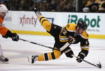BOSTON, MA - MAY 06:  Tomas Kaberle #12 of the Boston Bruins is tripped by Claude Giroux #28 of the Philadelphia Flyers in Game Four of the Eastern Conference Semifinals during the 2011 NHL Stanley Cup Playoffs at TD Garden on May 6, 2011 in Boston, Massa