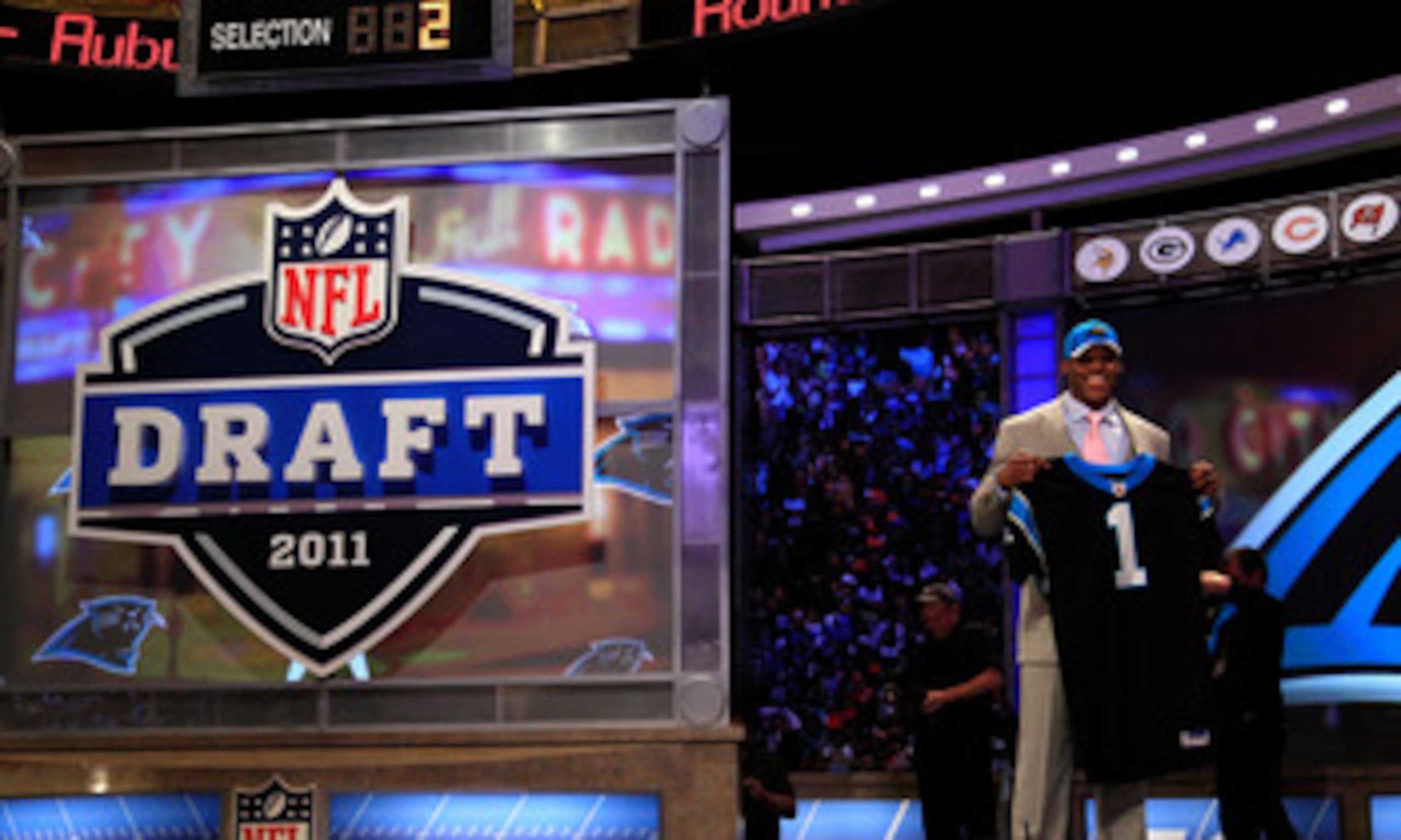 NEW YORK, NY - APRIL 28: Cam Newton, #1 overall pick by the Carolina Panthers holds up a jersey on stage after he was picked during the 2011 NFL Draft at Radio City Music Hall on April 28, 2011 in New York City. (Photo by Chris Trotman/Getty Images) NEW YORK, NY - APRIL 28: Cam Newton, #1 overall pick by the Carolina Panthers holds up a jersey on stage after he was picked during the 2011 NFL Draft at Radio City Music Hall on April 28, 2011 in New York City. (Photo by Chris Trotman/Getty Images)