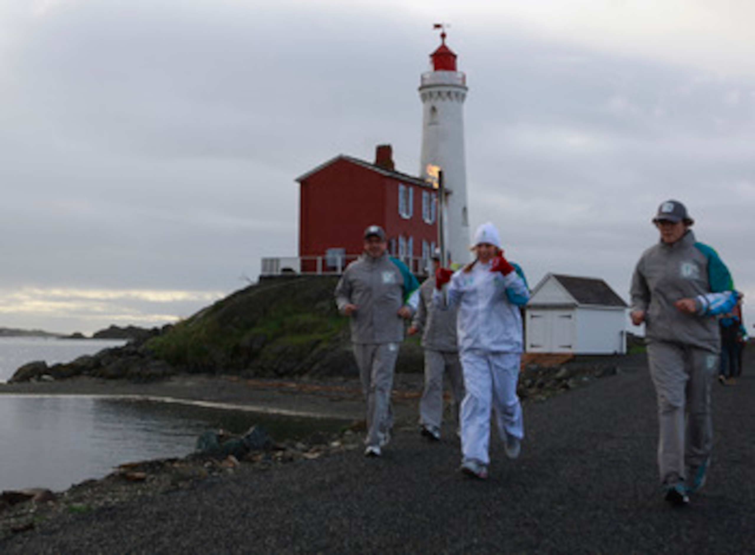 COLWOOD, BRITISH COLUMBIA - OCTOBER 31:   Laura Mongeau carries the Olympic torch during the Olympic Torch relay on October 31, 2009 in front of Fisgard Lighthouse at Fort Rodd Hill National Historic Site in Colwood, British Columbia, Canada.  The Olympic
