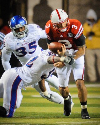 LINCOLN, NE - NOVEMBER 13: Taylor Martinez #3 of the Nebraska Cornhuskers gets the ball knocked from his arms by Steven Johnson #52 of the Kansas Jayhawks during second half action of their game at Memorial Stadium on November 13, 2010 in Lincoln, Nebrask