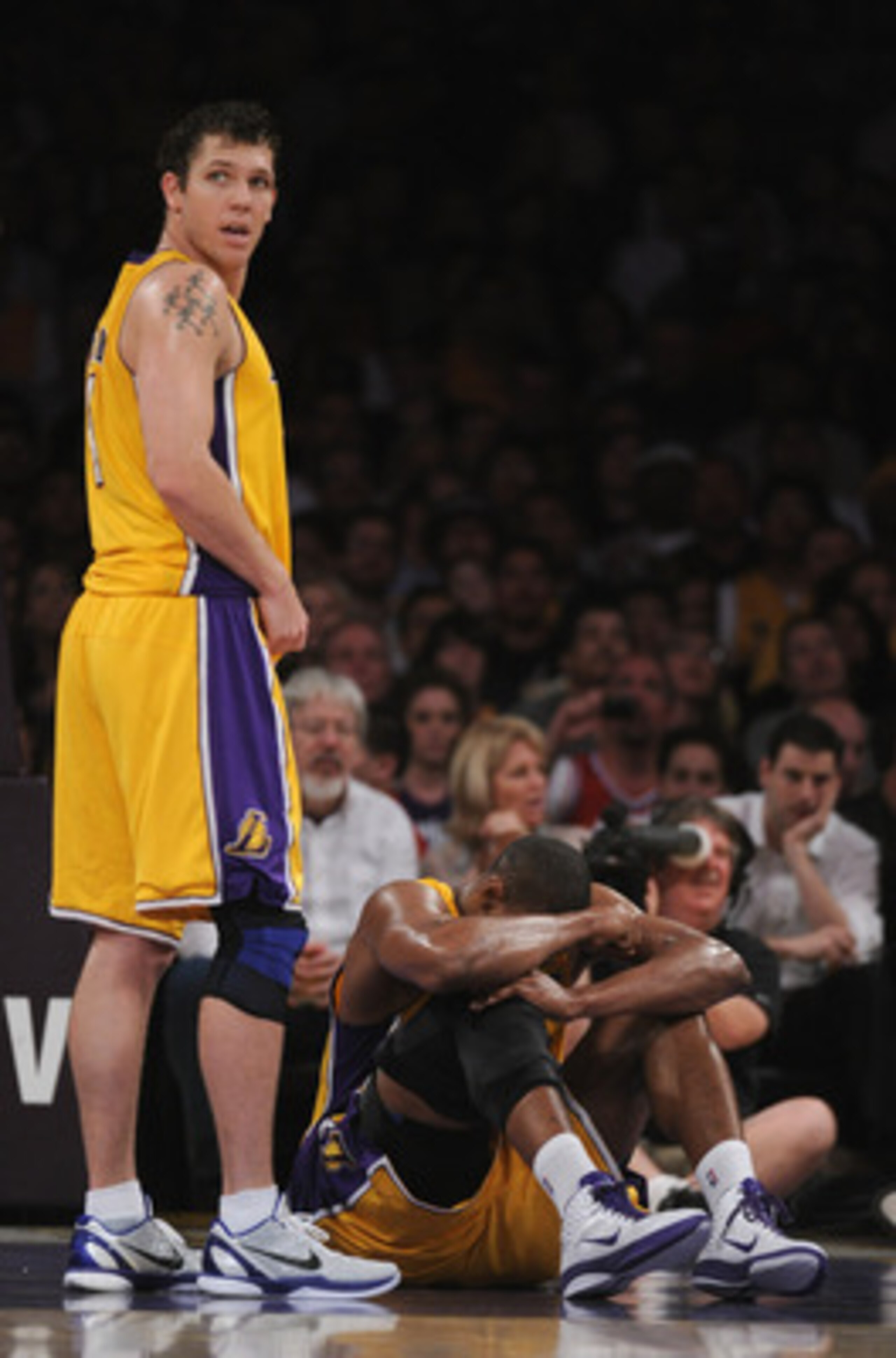 LOS ANGELES, CA - APRIL 12:  Luke Walton #4 of the Los Angeles Lakers looks back at the bench as  Andrew Bynum #17 sits on the floor after an injury during the game against the San Antonio Spurs at Staples Center on April 12, 2011 in Los Angeles, Californ