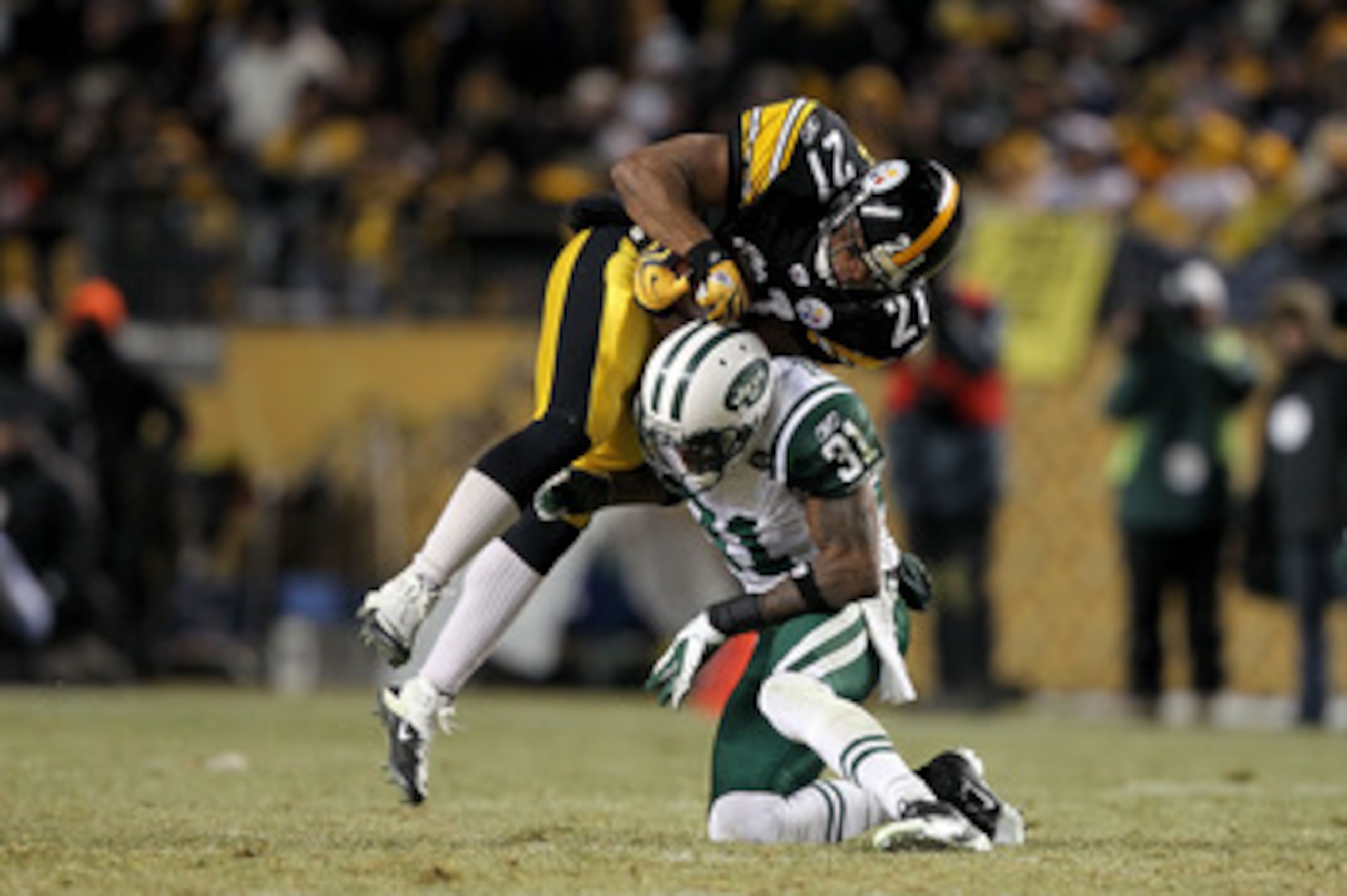 PITTSBURGH, PA - JANUARY 23:  Mewelde Moore #21 of the Pittsburgh Steelers catches a pass over Antonio Cromartie #31 of the New York Jets in the third quarter of the 2011 AFC Championship game at Heinz Field on January 23, 2011 in Pittsburgh, Pennsylvania