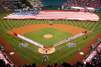 ANAHEIM, CA - OCTOBER 08:  The Los Angeles Angels of Anaheim and the Boston Red Sox stand for the National Anthem in front of a giant American flag before in Game One of the ALDS during the 2009 MLB Playoffs at Angel Stadium on October 8, 2009 in Anaheim,
