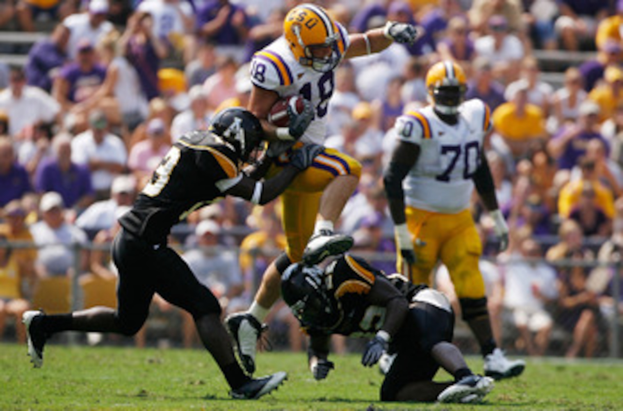 BATON ROUGE, LA - AUGUST 30:  Richard Dickson #18 of the Louisiana State University Tigers jumps over Justin Johnson #55 of the Appalachian State Mountaineers on August 30, 2008 at Tiger Stadium in Baton Rouge, Louisiana.  (Photo by Chris Graythen/Getty I