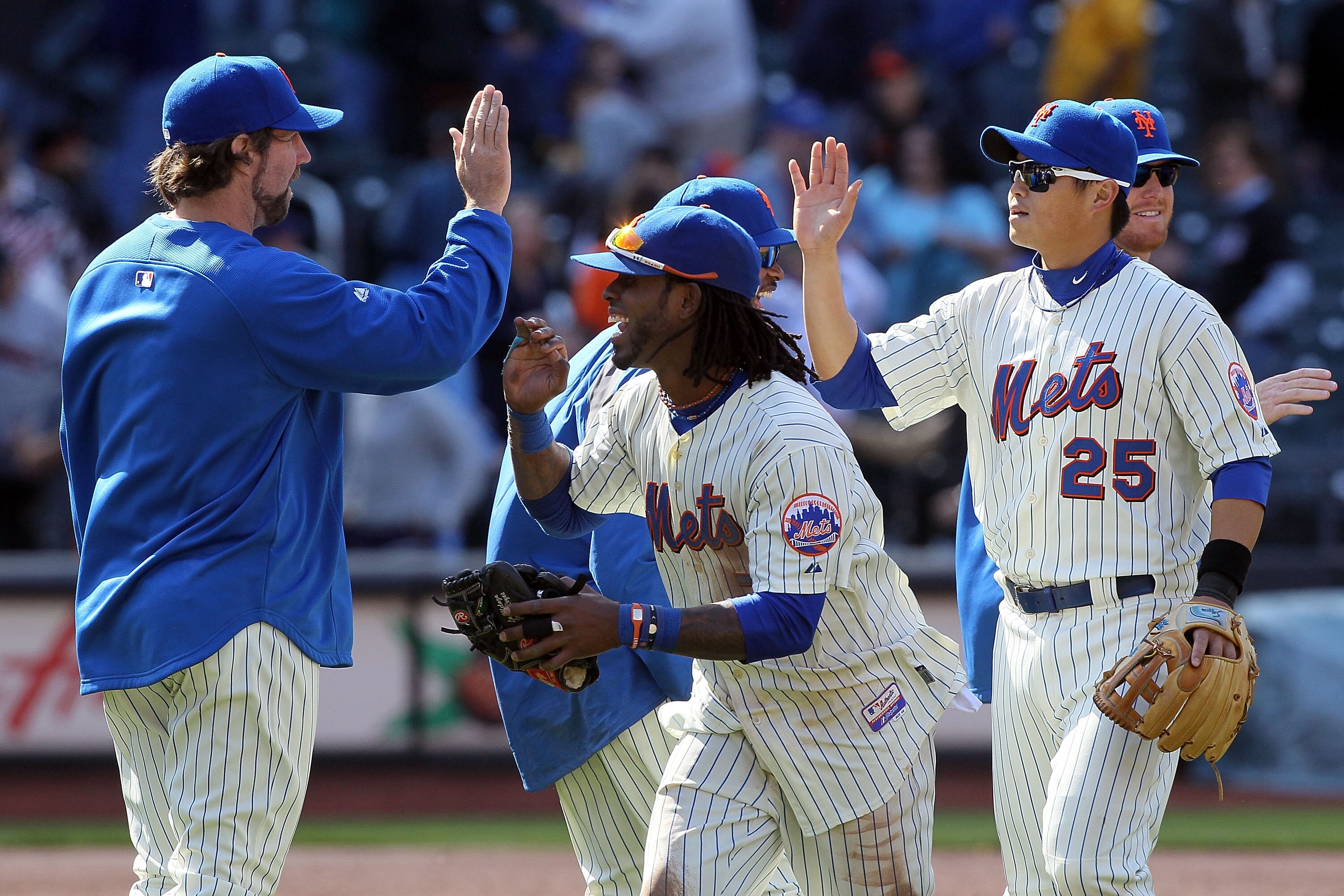 NEW YORK, NY - MAY 05:  R.A. Dickey #43, Jose Reyes #7, and Chin-lung Hu #25 of the New York Mets celebrate after defeating the San Francisco Giants on May 5, 2011 at Citi Field in the Flushing neighborhood of the Queens borough of New York City. The Mets