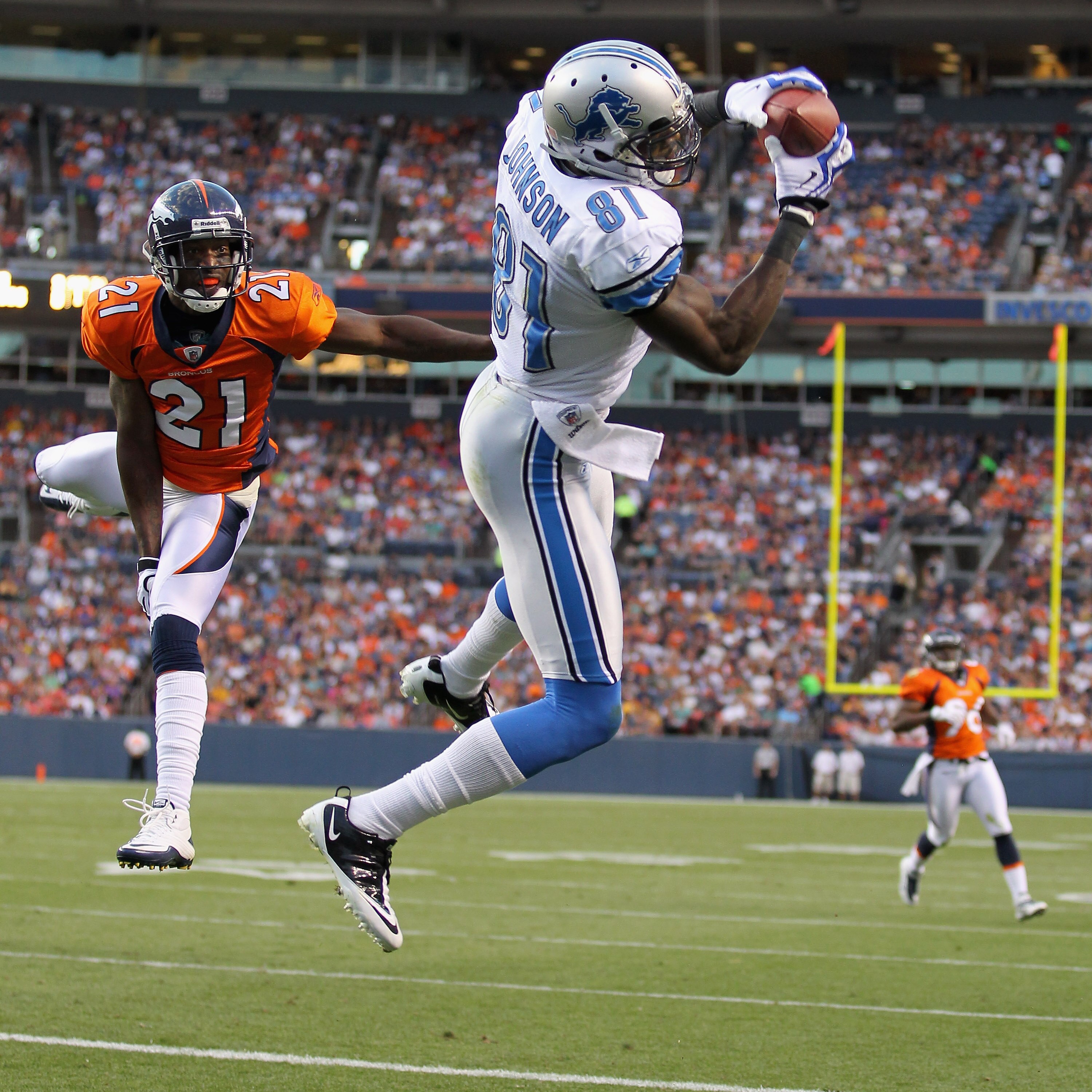 DENVER - AUGUST 21:  Calvin Johnson  #81 of the Detroit Lions makes a 20 yard touchdown catch as Andre Goodman #21 of the Denver Broncos defends during preseason NFL action at INVESCO Field at Mile High on August 21, 2010 in Denver, Colorado. The touchdow