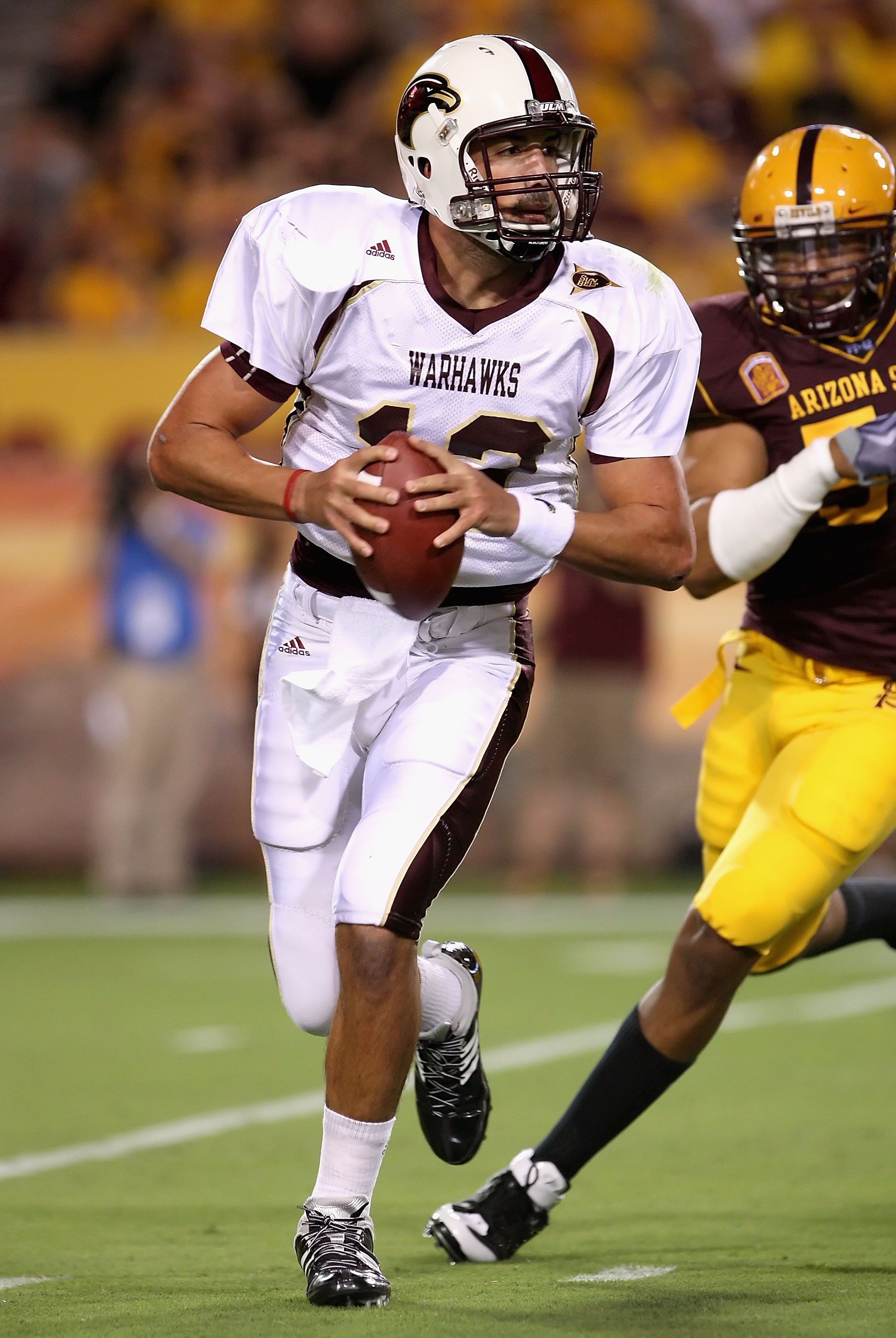 TEMPE, AZ - SEPTEMBER 19:  Quarterback Trey Revell #12 of the Louisiana Monroe Warhawks scrambles with the ball under pressure from Dexter Davis #58 of the Arizona State Sun Devils during the college football game at Sun Devil Stadium on September 19, 200