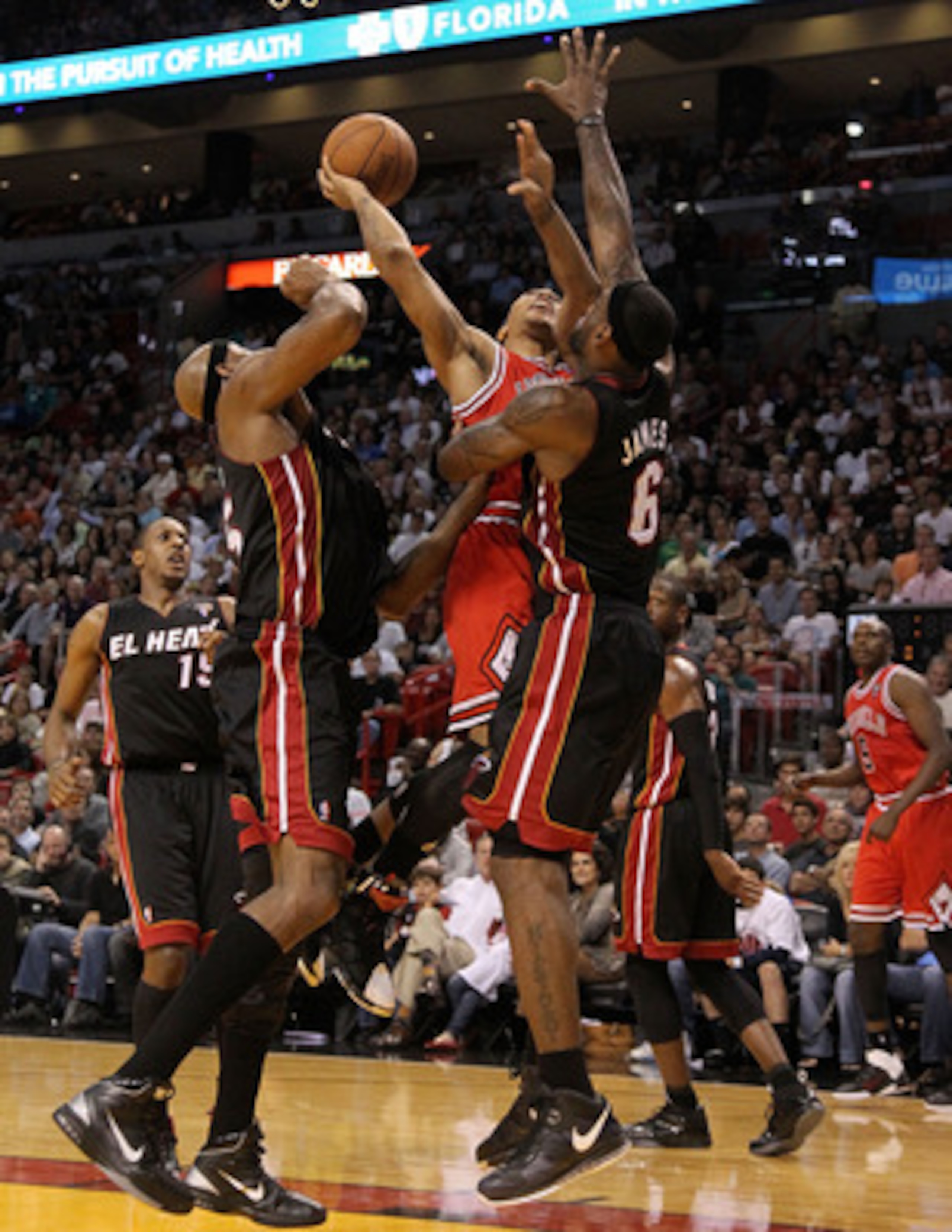 MIAMI, FL - MARCH 06:  Derrick Rose #1 of  the Chicago Bulls shoots over LeBron James #6 and Eric Dampier #25 of the Miami Heat during a game at American Airlines Arena on March 6, 2011 in Miami, Florida. NOTE TO USER: User expressly acknowledges and agre