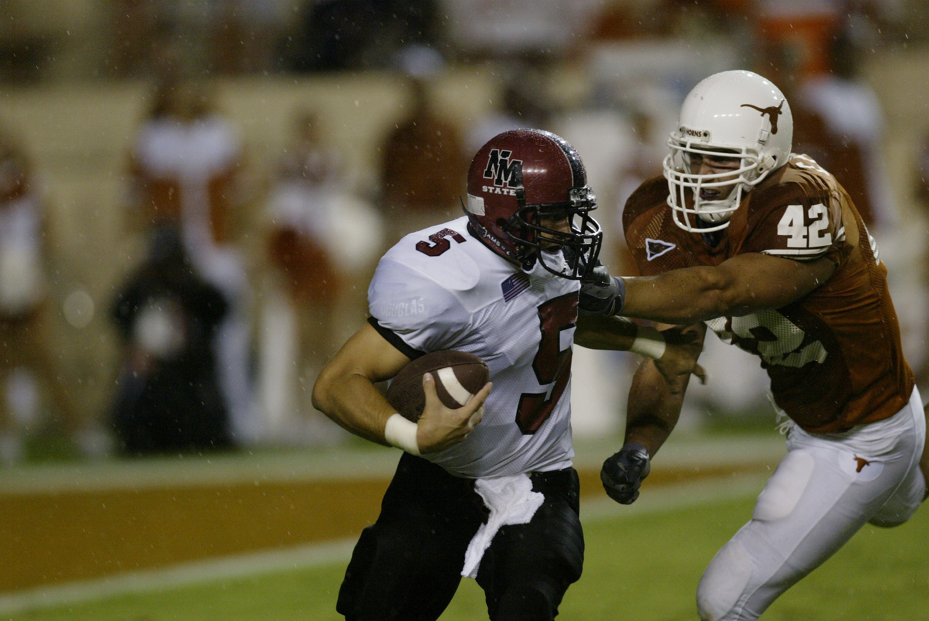 AUSTIN, TX - AUGUST 31:  Quarterback Joey Vincent #5 of the New Mexico State University Aggies is tackled for a loss by defensive end Chase Pittman #42 of the University of Texas at Austin Longhorns at Texas Memorial Stadium on August 31, 2003 in Austin,