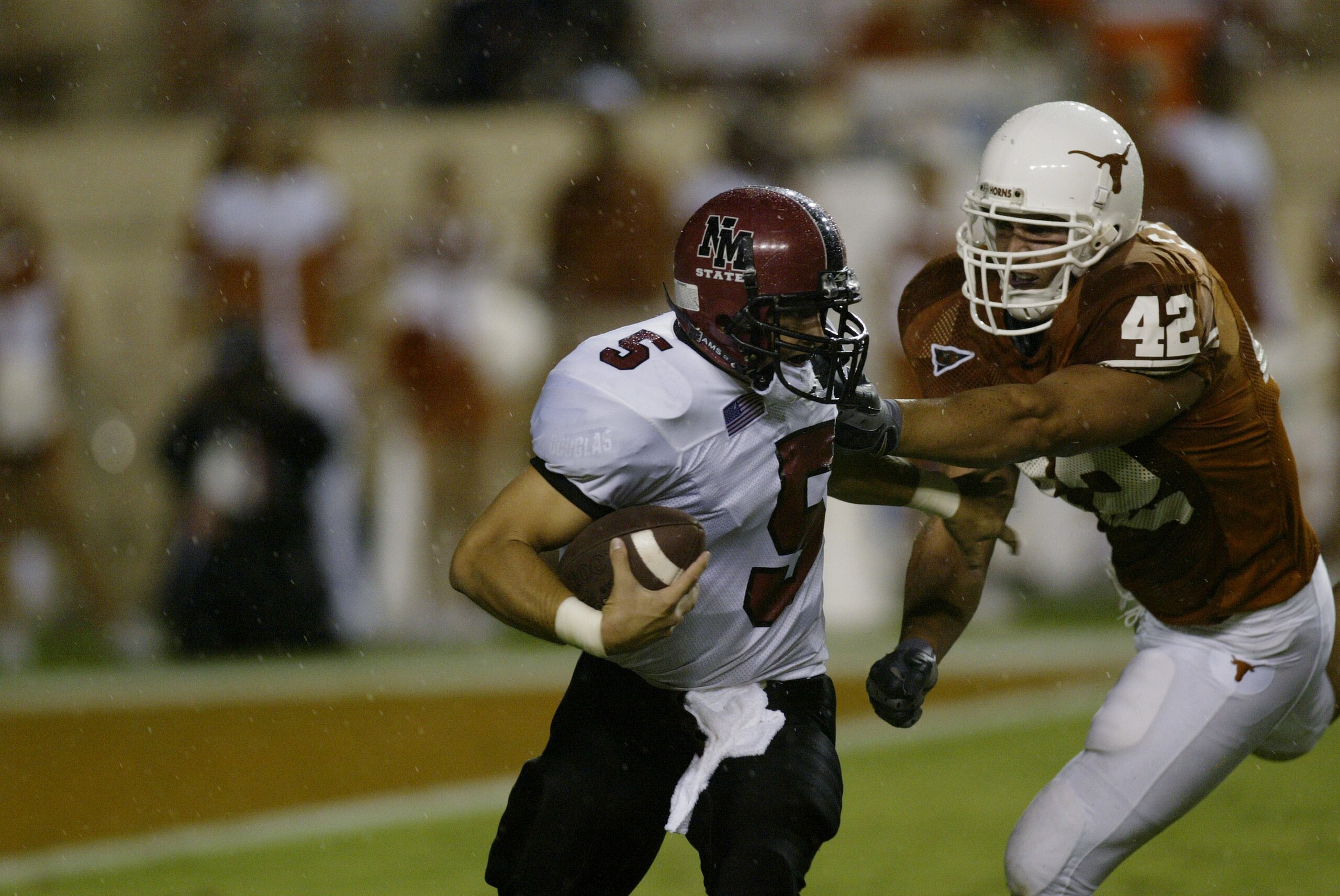 AUSTIN, TX - AUGUST 31:  Quarterback Joey Vincent #5 of the New Mexico State University Aggies is tackled for a loss by defensive end Chase Pittman #42 of the University of Texas at Austin Longhorns at Texas Memorial Stadium on August 31, 2003 in Austin,