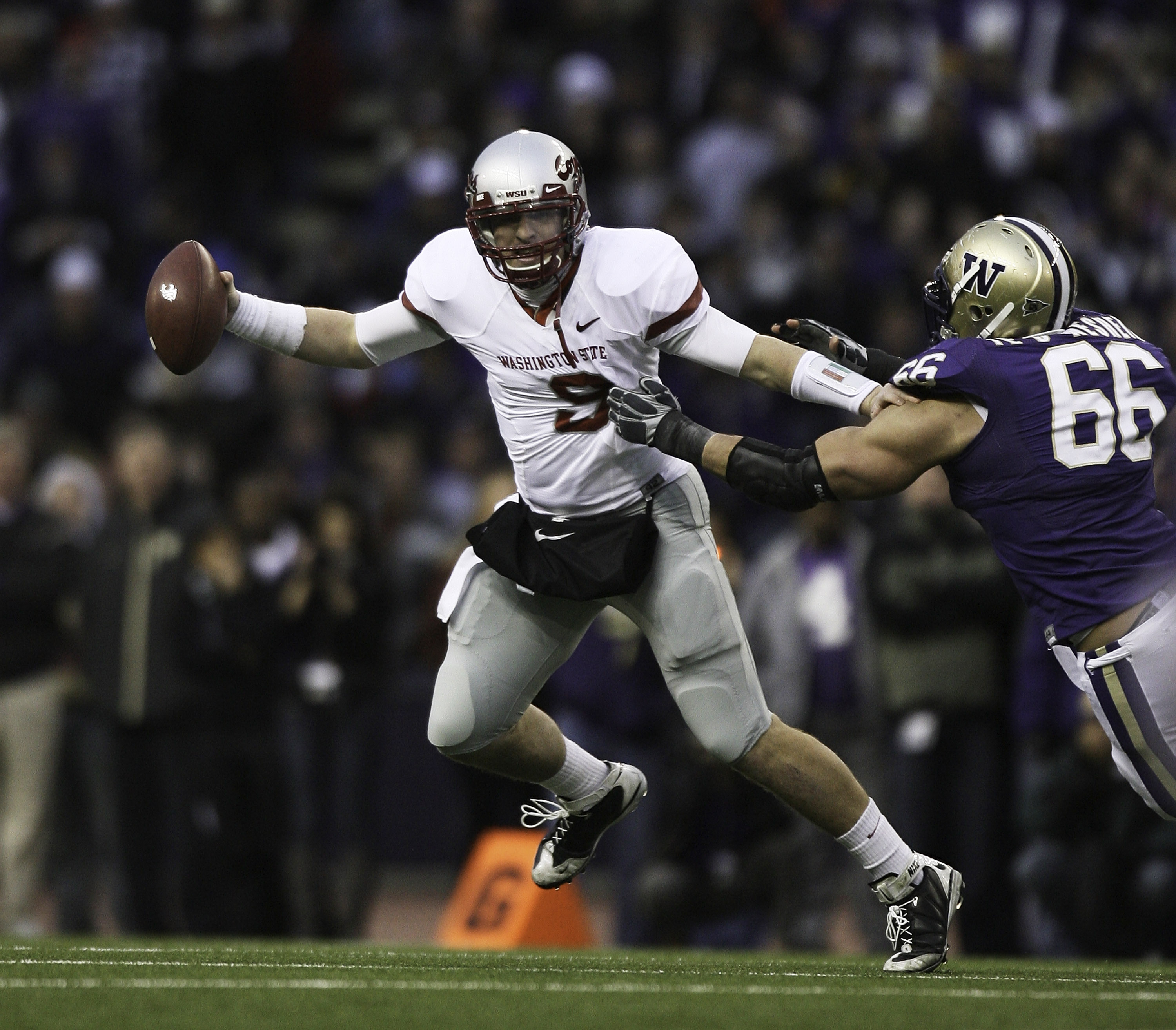 SEATTLE - NOVEMBER 28:  Quarterback Kevin Lopina #9 of the Washington State Cougars scrambles against Daniel Te'o-Nesheim #66 of the Washington Huskies on November 28, 2009 at Husky Stadium in Seattle, Washington. The Huskies defeated the Cougars 30-0. (P