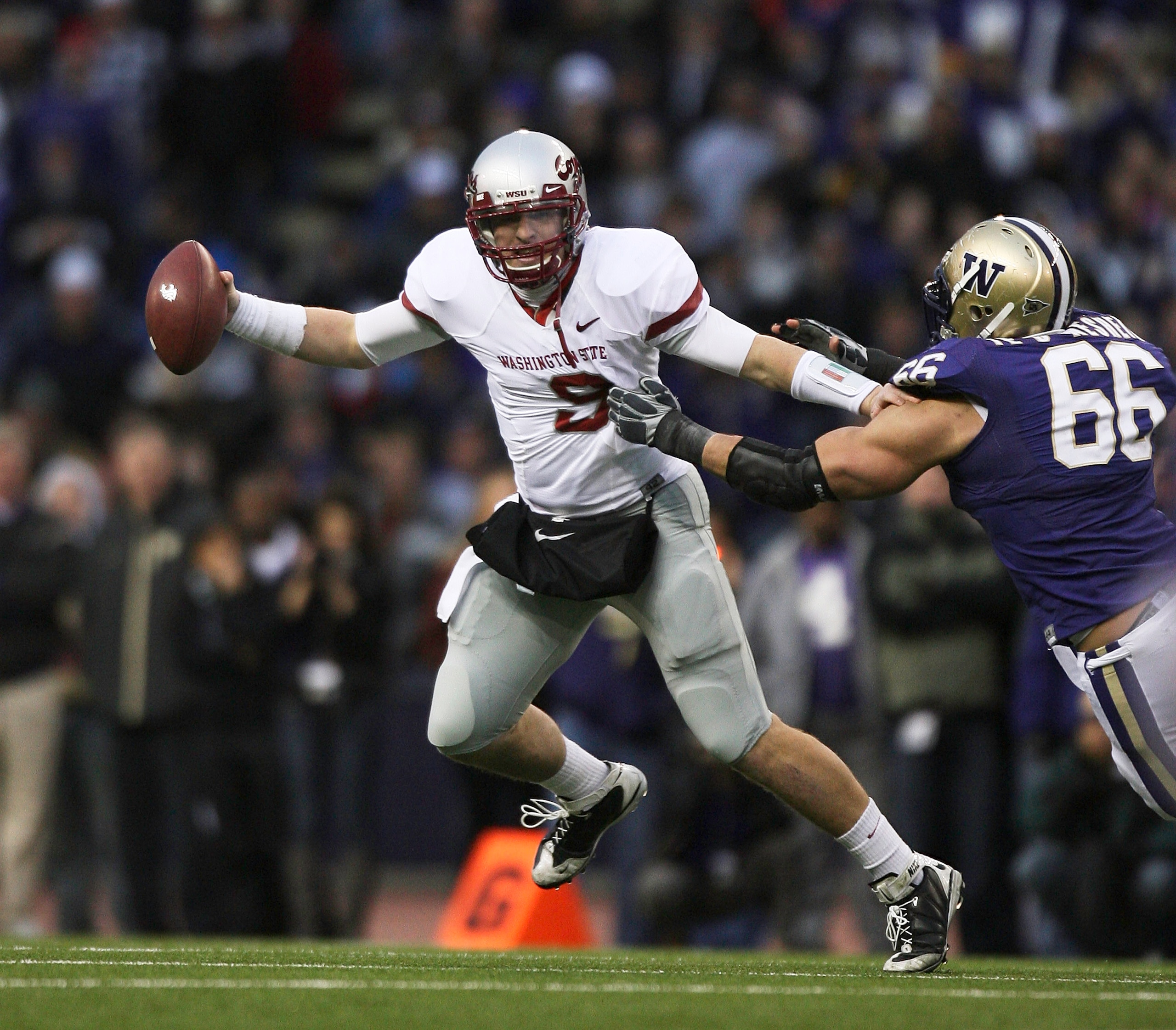 SEATTLE - NOVEMBER 28:  Quarterback Kevin Lopina #9 of the Washington State Cougars scrambles against Daniel Te'o-Nesheim #66 of the Washington Huskies on November 28, 2009 at Husky Stadium in Seattle, Washington. The Huskies defeated the Cougars 30-0. (P