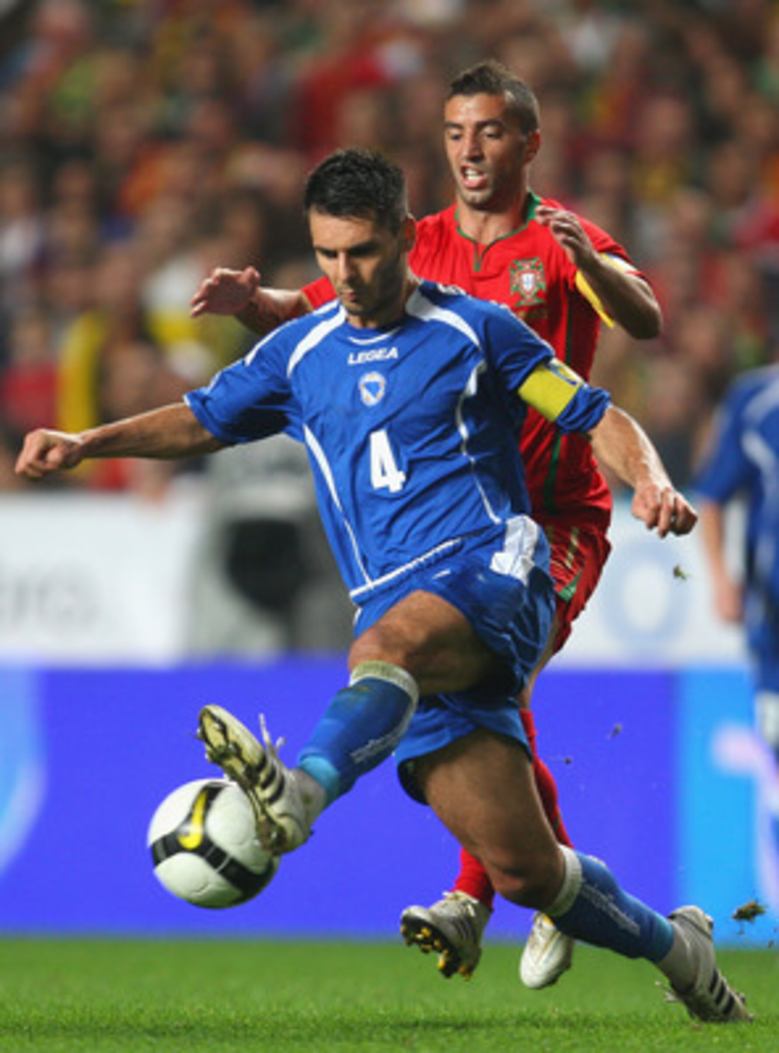 LISBON, PORTUGAL - NOVEMBER 14:  Simao Sabrosa of Portugal tangles with Emir Spahic of Bosnia during the FIFA 2010 European World Cup qualifier first leg match between Portugal and Bosnia-Herzegovina at the Luz stadium on November 14, 2009 in Lisbon, Port