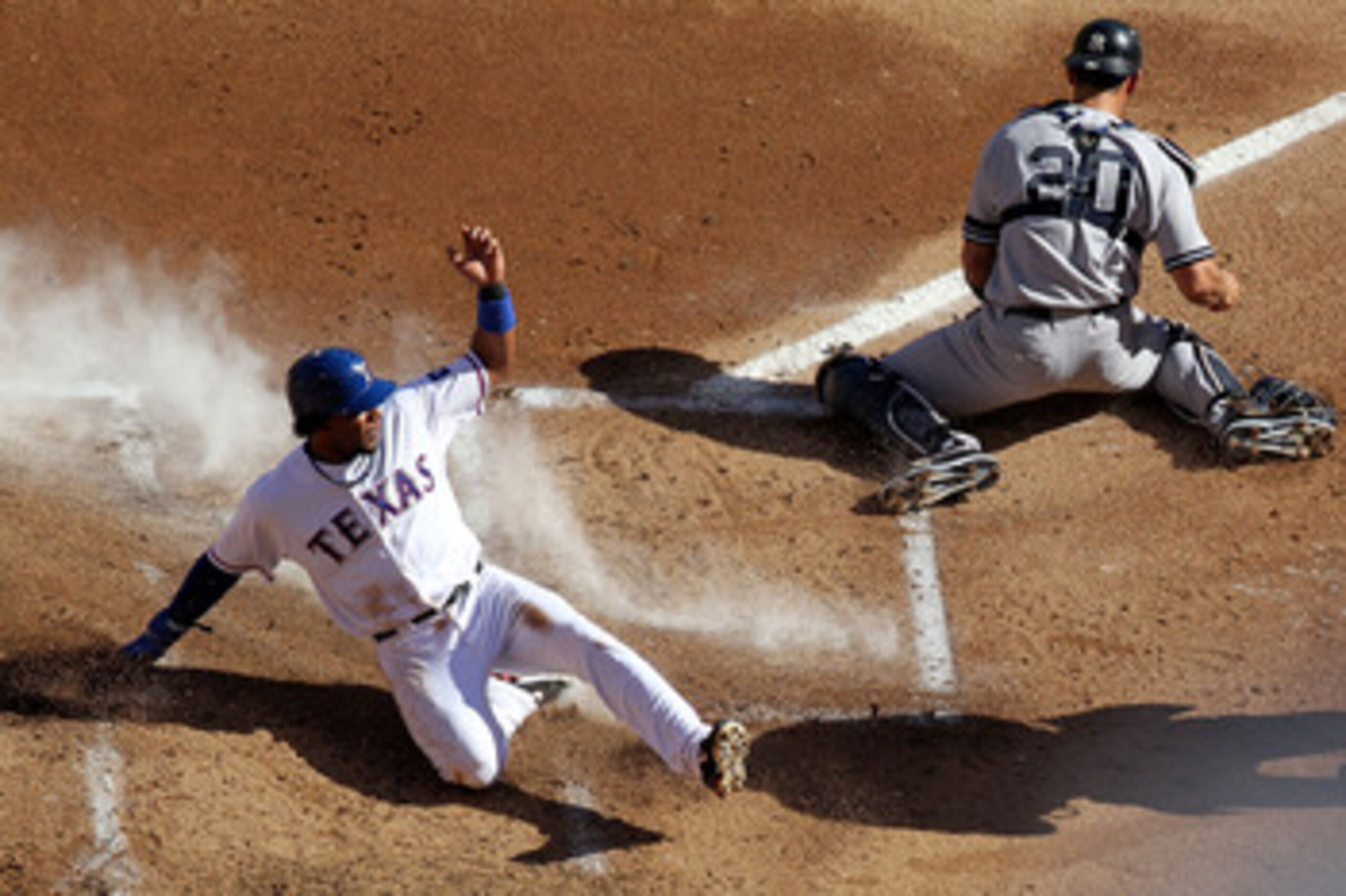 ARLINGTON, TX - OCTOBER 16:  Elvis Andrus #1 of the Texas Rangers slides into home plate to score on a double steal in the bottom of the first inning against Jorge Posada #20 of the New York Yankees in Game Two of the ALCS during the 2010 MLB Playoffs at