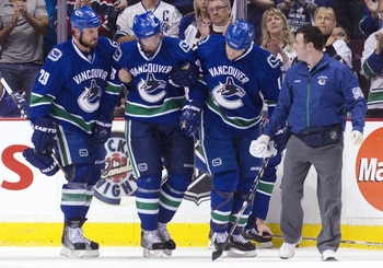 VANCOUVER, CANADA - MAY 7: Mikael Samuelsson #26 of the Vancouver Canucks being helped off the ice by teammates Aaron Rome #29 and Sami Salo #6 of the Vancouver Canucks.  During the first period in Game Five against the Nashville Predators in the Western 