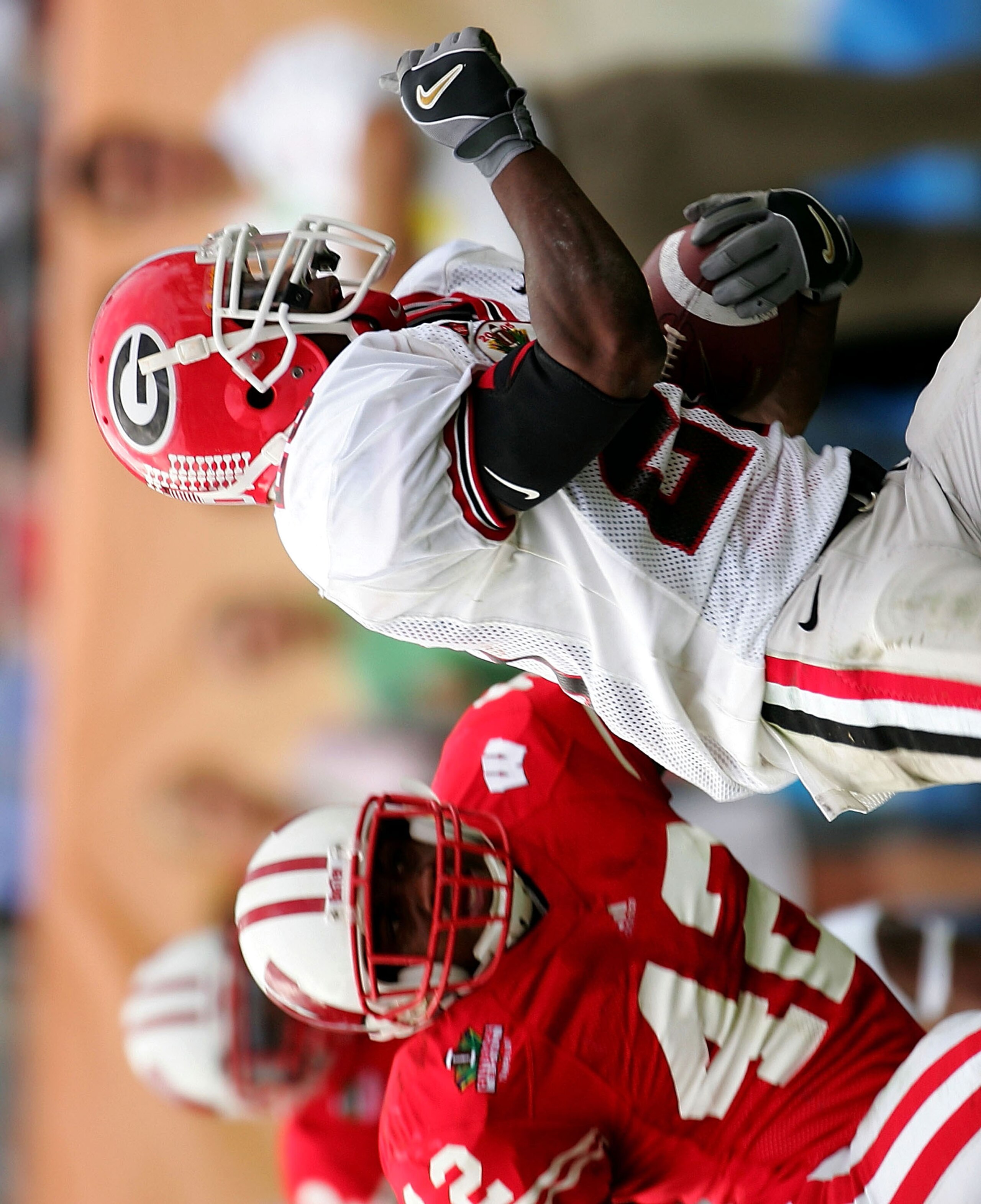 TAMPA, FL - JANUARY 1:  Georgia tailback Thomas Brown #20 runs away from Wisconsin defender Robert Brooks #42 for a touchdown during the second half of the Outback Bowl on January 1, 2005 at Raymond James Stadium in Tampa, Florida.  (Photo by Scott Haller