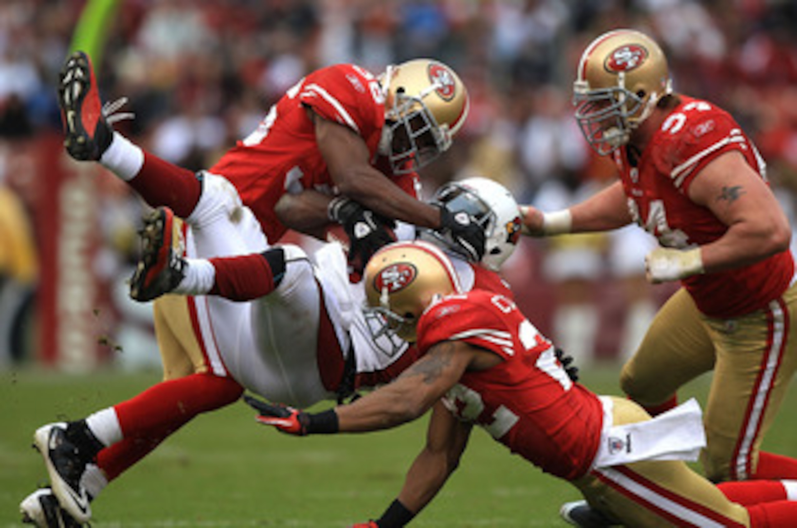 SAN FRANCISCO, CA - JANUARY 02:    Tim Hightower #34 of the Arizona Cardinals is tackled by Nate Clements #22 and Shawntae Spencer #36 of the San Francisco 49ers  during an NFL game at Candlestick Park on January 2, 2011 in San Francisco, California.  (Ph