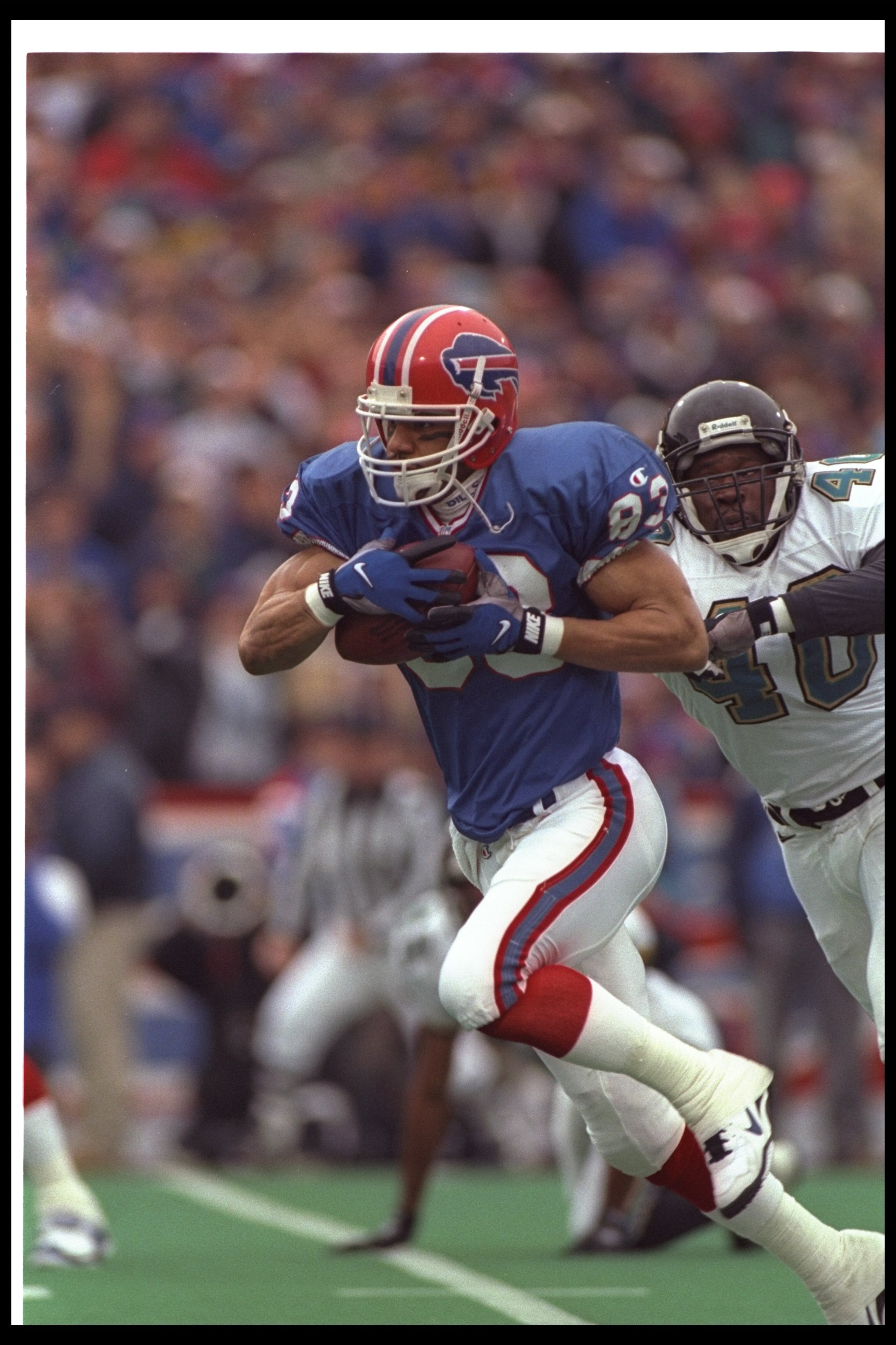 28 Dec 1996:  Wide receiver Andre Reed of the Buffalo Bills runs with the ball as Jacksonville Jaguars defensive back Robert Massey chases him during a playoff game at Rich Stadium in Orchard Park, New York.  The Jaguars won the game, 30-27. Mandatory Cre
