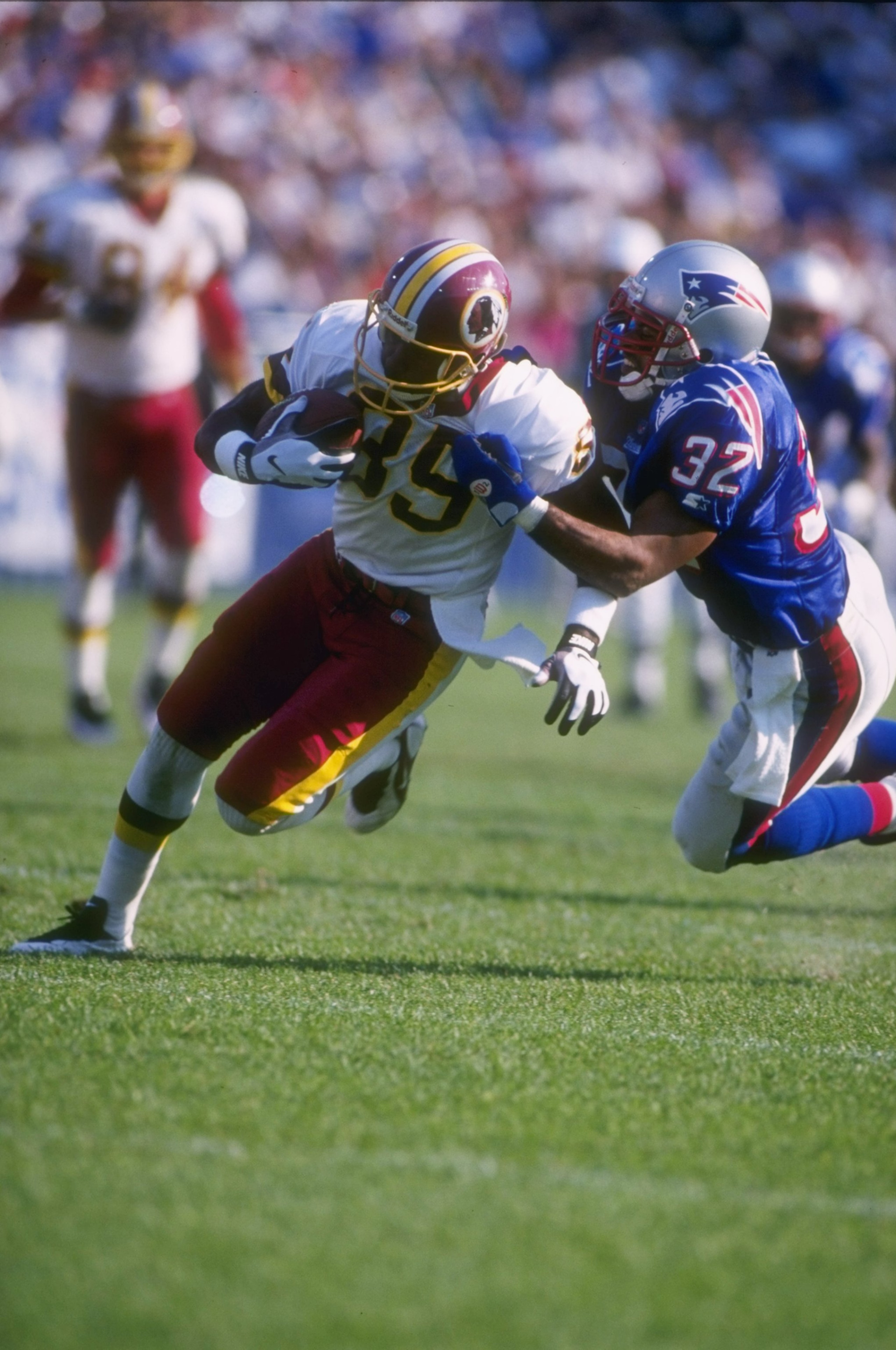 13 Oct 1996: Wide receiver Henry Ellard #89 of the Washington Redskins hangs onto the football as he attempts to run through the diving grasp of defensive back Willie Clay #32 of the New England Patriots following a recetpion in the Redskins 27-22 victory