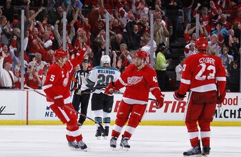 DETROIT - MAY 10: Darren Helm #43 of the Detroit Red Wings celebrates his third period empty net goal with Nicklas Lidstrom #5 and Brad Stuart #23 while playing the San Jose Sharks in Game Six of the Western Conference Semifinals during the 2011 NHL Stanl