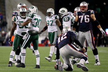FOXBORO, MA - JANUARY 16:  Tom Brady #12 of the New England Patriots gets up after being sacked by Drew Coleman #30 of the New York Jets during their 2011 AFC divisional playoff game at Gillette Stadium on January 16, 2011 in Foxboro, Massachusetts.  (Pho