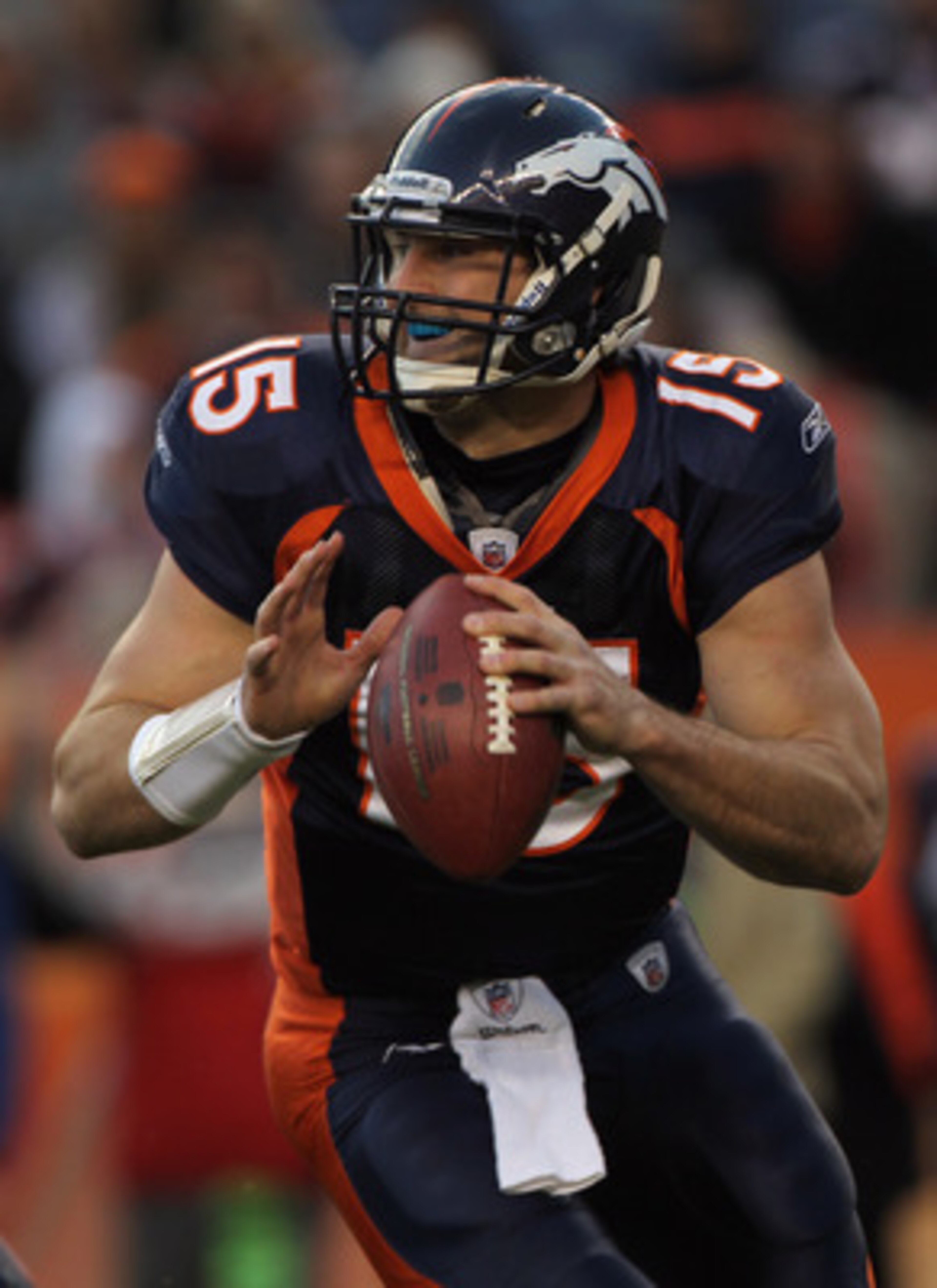 DENVER - DECEMBER 26:  Quarterback Tim Tebow #15 of the Denver Broncos rolls out and looks to deliver a pass against the Houston Texas at INVESCO Field at Mile High on December 26, 2010 in Denver, Colorado. The Broncos defeated the Texans 24-23.  (Photo b