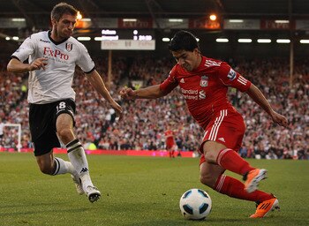 LONDON, ENGLAND - MAY 09:  Luis Suarez of Liverpool is challenged by Aaron Hughes of Fulham during the Barclays Premier League match between Fulham and Liverpool at Craven Cottage on May 9, 2011 in London, England.  (Photo by Scott Heavey/Getty Images)