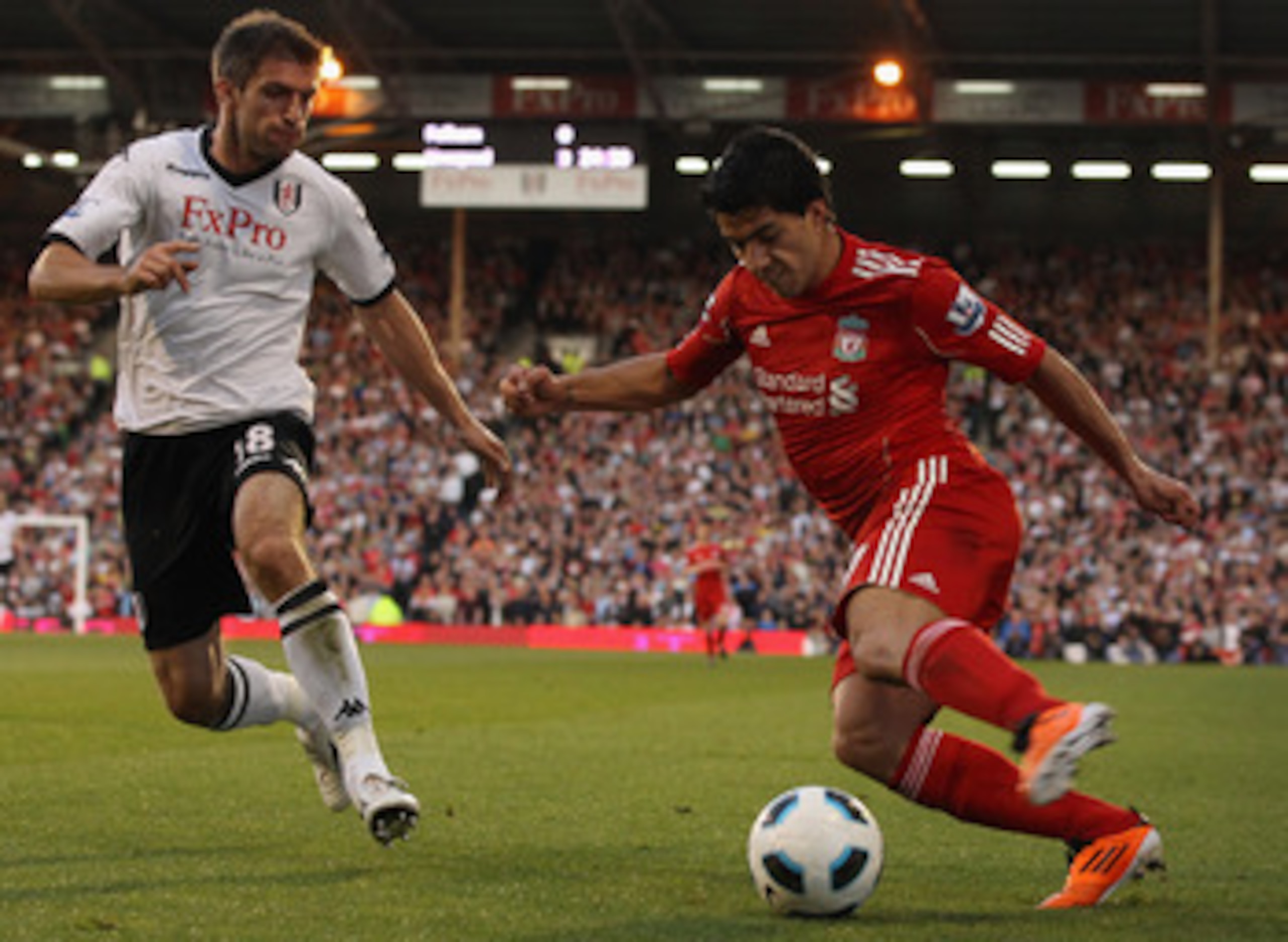 LONDON, ENGLAND - MAY 09:  Luis Suarez of Liverpool is challenged by Aaron Hughes of Fulham during the Barclays Premier League match between Fulham and Liverpool at Craven Cottage on May 9, 2011 in London, England.  (Photo by Scott Heavey/Getty Images)