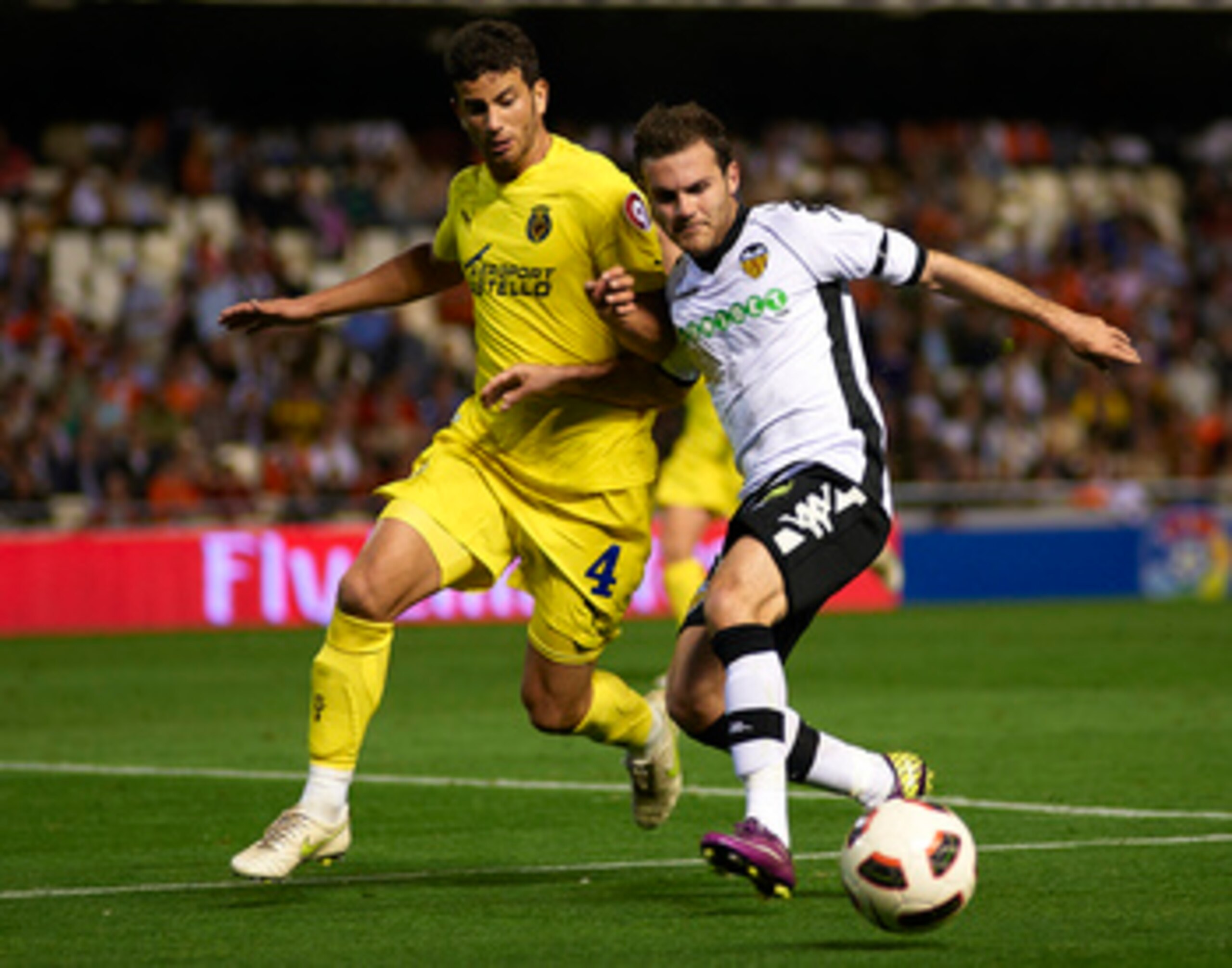 VALENCIA, VALENCIA - APRIL 10: Juan Mata (R) of Valencia duels for the ball with Mateo Musacchio of Villarreal during the La Liga match between Valencia and Villarreal at Estadio Mestalla on April 10, 2011 in Valencia, Spain.  (Photo by Manuel Queimadelos