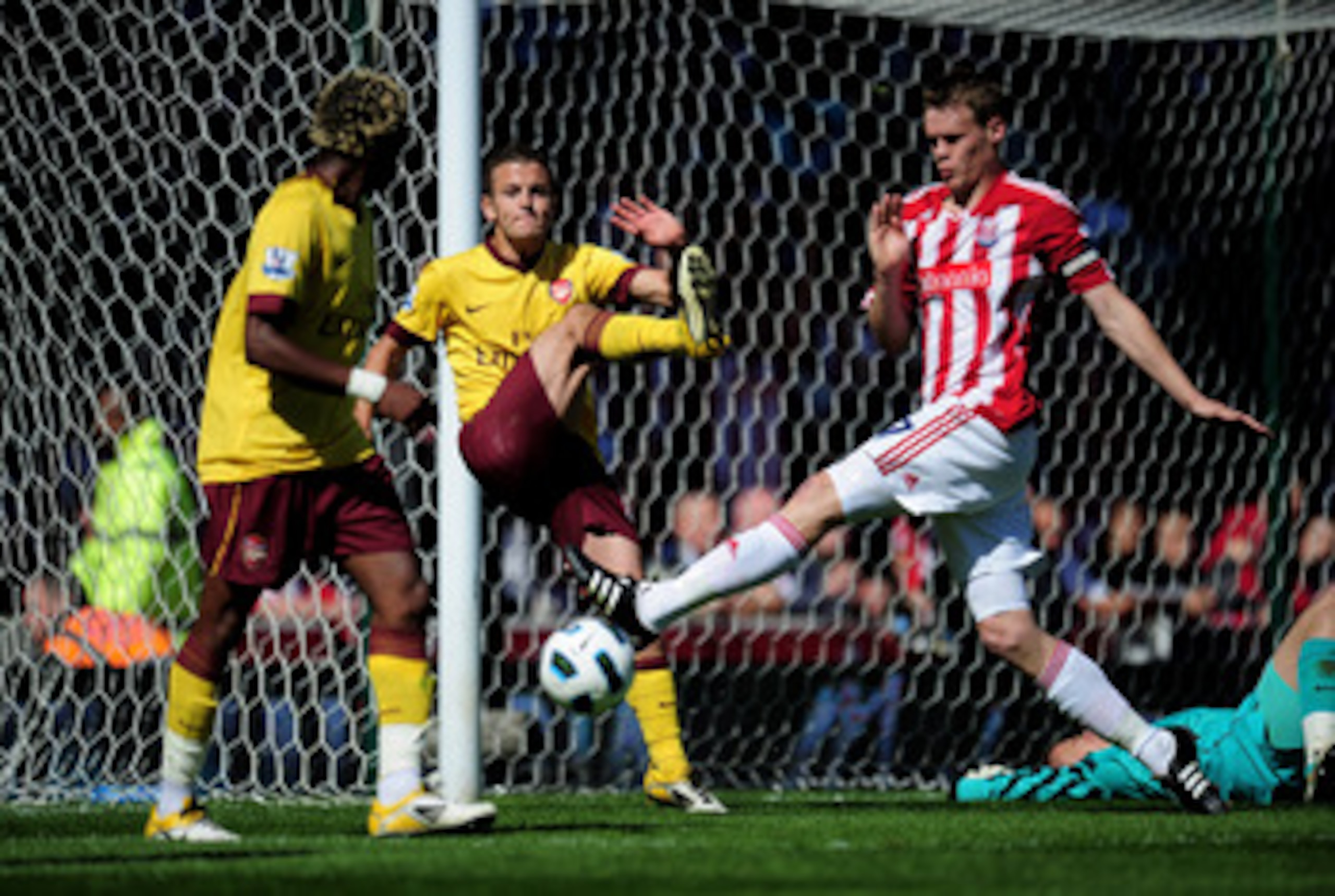 STOKE ON TRENT, ENGLAND - MAY 08:  Jack Wilshere of Arsenal clears the ball off his own goal line as Ryan Shawcross of Stoke closes in during the Barclays Premier League match between Stoke City and Arsenal at the Britannia Stadium on May 8, 2011 in Stoke
