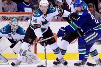 VANCOUVER, CANADA - JANUARY 20: Marc-Edouard Vlasic #44 of the San Jose Sharks holds off Daniel Sedin #22 of the Vancouver Canucks while trying to clear the puck during the third period in NHL action on January 20, 2011 at Rogers Arena in Vancouver, BC, C