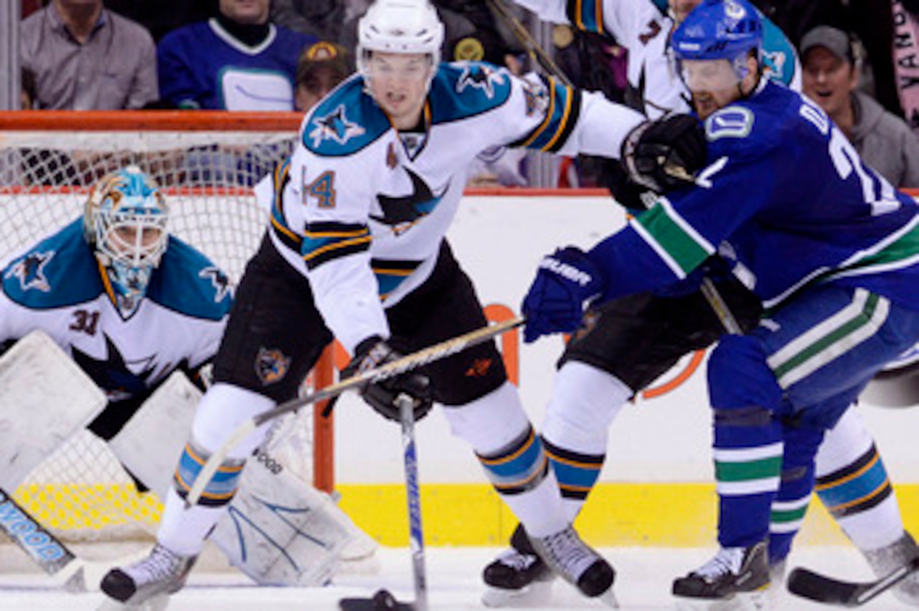 VANCOUVER, CANADA - JANUARY 20: Marc-Edouard Vlasic #44 of the San Jose Sharks holds off Daniel Sedin #22 of the Vancouver Canucks while trying to clear the puck during the third period in NHL action on January 20, 2011 at Rogers Arena in Vancouver, BC, C