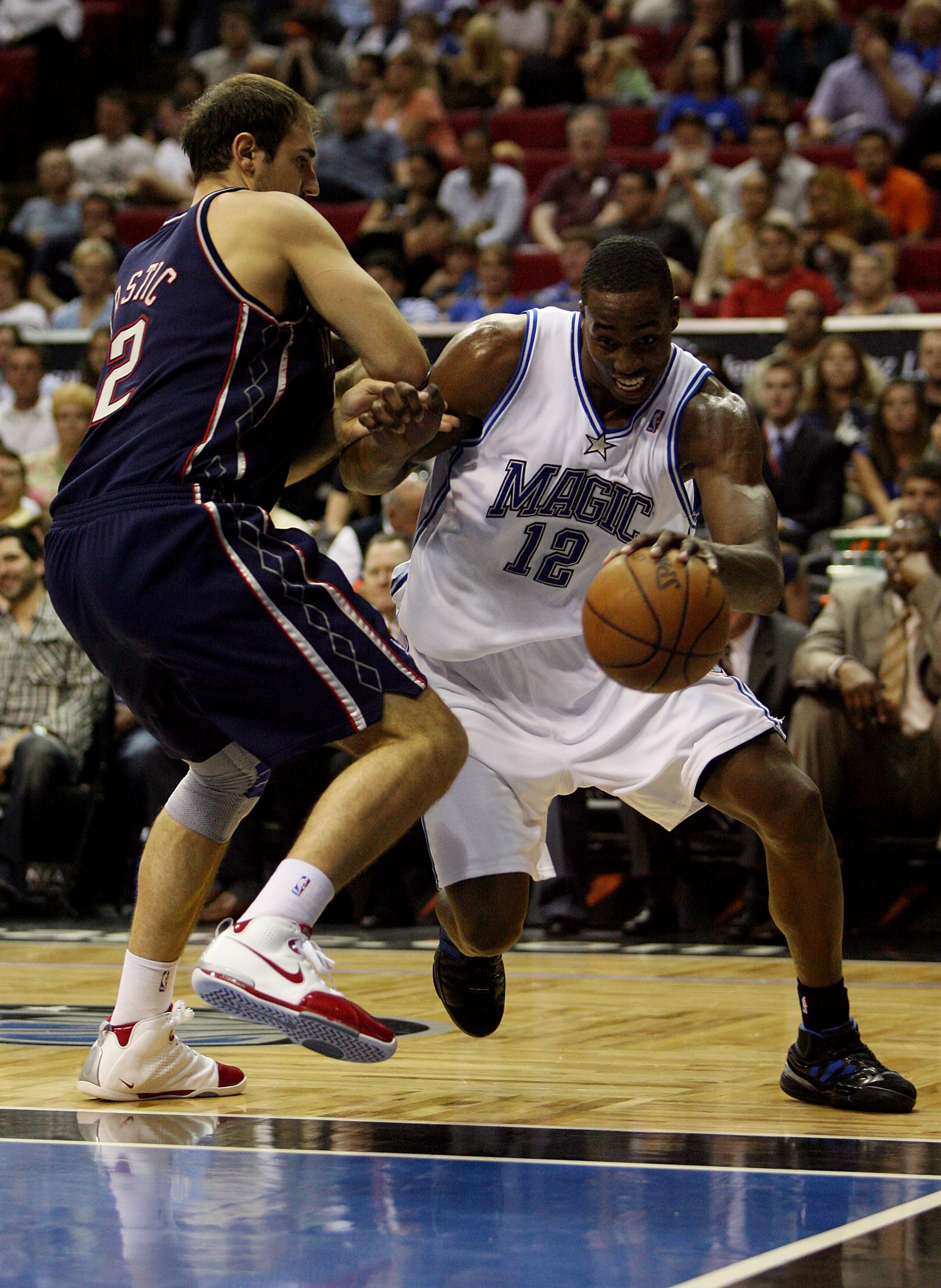 ORLANDO, FL - FEBRUARY 06:  Dwight Howard #12 of the Orlando Magic drives past Nenad Krstic #12 of the New Jersey Nets at Amway Arena on February 6, 2008 in Orlando, Florida. The Magic defeated the Nets 100-84. NOTE TO USER: User expressly acknowledges an