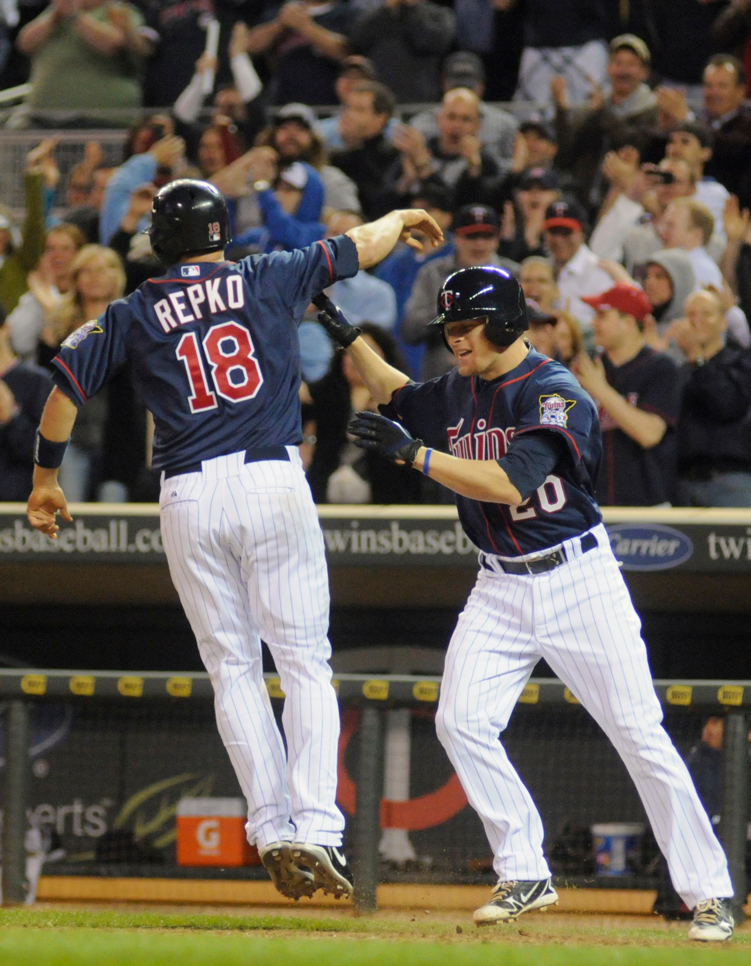 MINNEAPOLIS, MN - APRIL 12: Jason Repko #18 and Matt Tolbert #20 of the Minnesota Twins celebrate Repko scoring the winning run against the Kansas City Royals during the tenth inning of their game on April 12, 2011 at Target Field in Minneapolis, Minnesot