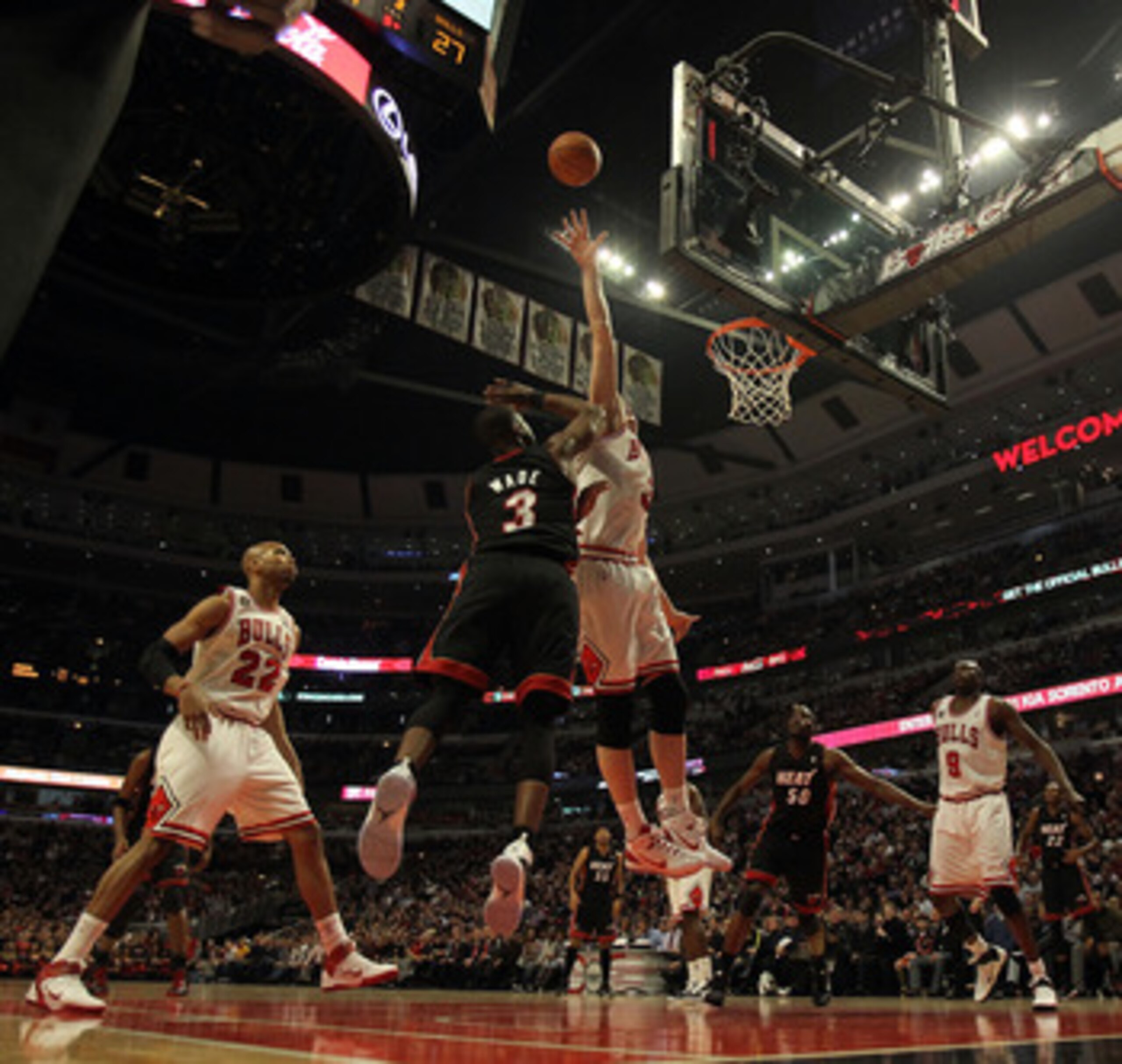 CHICAGO, IL - FEBRUARY 24: Omer Asik #3 of the Chicago Bulls leaps to try and block a shot by Dwyane Wade #3 of the Miami Heat at the United Center on February 24, 2011 in Chicago, Illinois. The Bulls defeated the Heat 93-89. NOTE TO USER: User expressly 