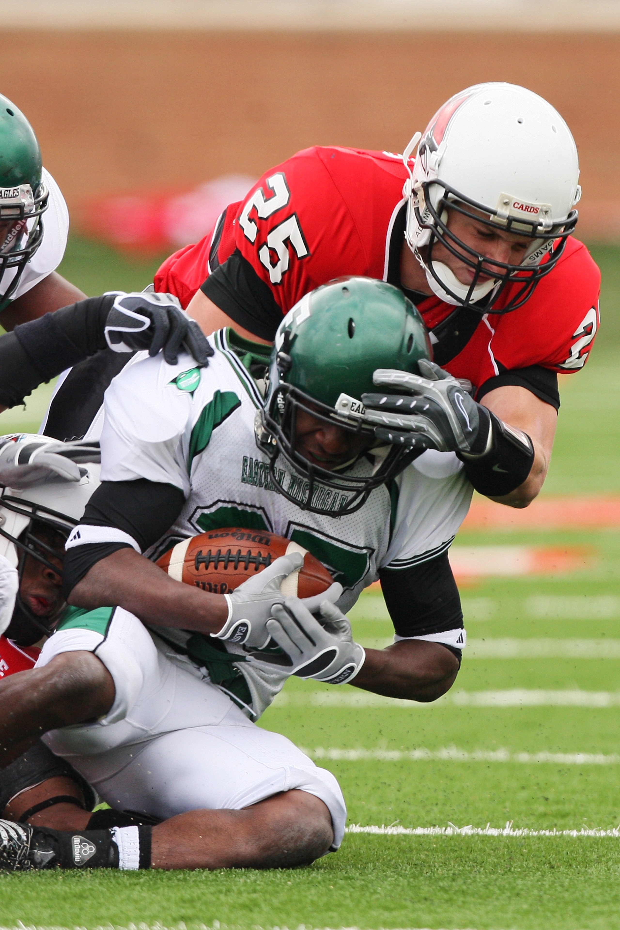 MUNCIE, IN - OCTOBER 25: Wide receiver Marvon Sanders #27 of the Eastern Michigan Eagles is brought down by defensive back Sean Baker of the Ball State Cardinals on October 25, 2008 at Scheumann Stadium in Muncie, Indiana.  (Photo by Jamie Sabau/Getty Ima