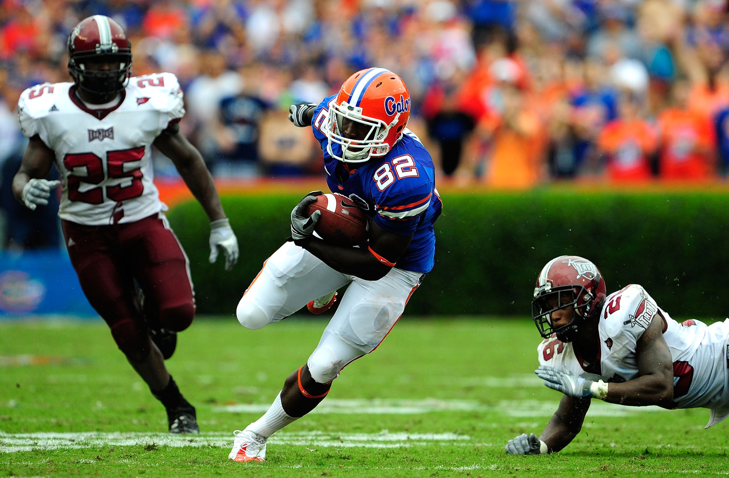 GAINESVILLE, FL - SEPTEMBER 12:  Omarius Hines #82 of the Florida Gators runs past Bryan Willis #26 and Xavier Lamb #25 of the Troy Trojans during game at Ben Hill Griffin Stadium on September 12, 2009 in Gainesville, Florida.  (Photo by Sam Greenwood/Get