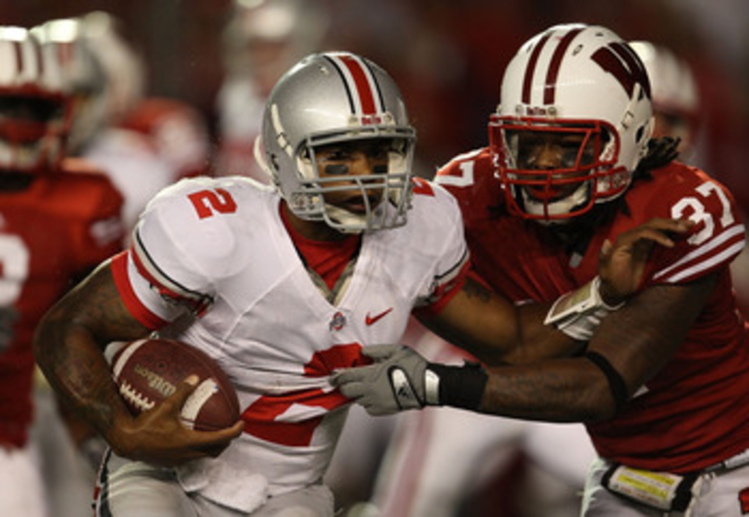 MADISON, WI - OCTOBER 16: Terrelle Pryor #2 of the Ohio State Buckeyes tries to break away from Kevin Claxton #37 of the Wisconsin Badgers at Camp Randall Stadium on October 16, 2010 in Madison, Wisconsin. Wisconsin defeated Ohio State 31-18.  (Photo by J