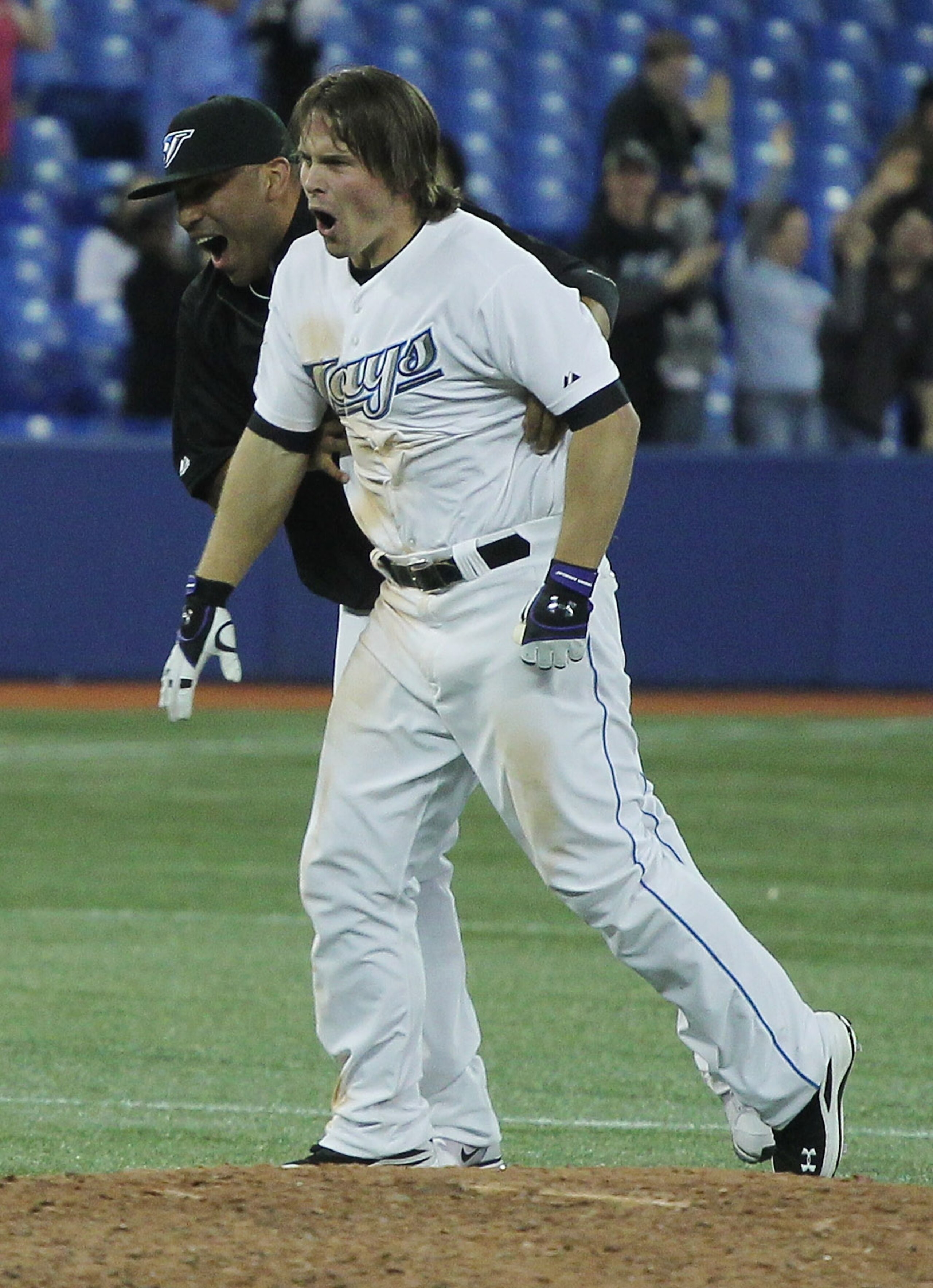 TORONTO, ON - APRIL 19:  Travis Snider #45 (R) and Ricky Romero #24 of the Toronto Blue Jays celebrate after Snider drove in the winning run in the tenth inning to defeat New York Yankees 6-5 at Rogers Centre on April 19, 2011 in Toronto, Canada. (Photo b