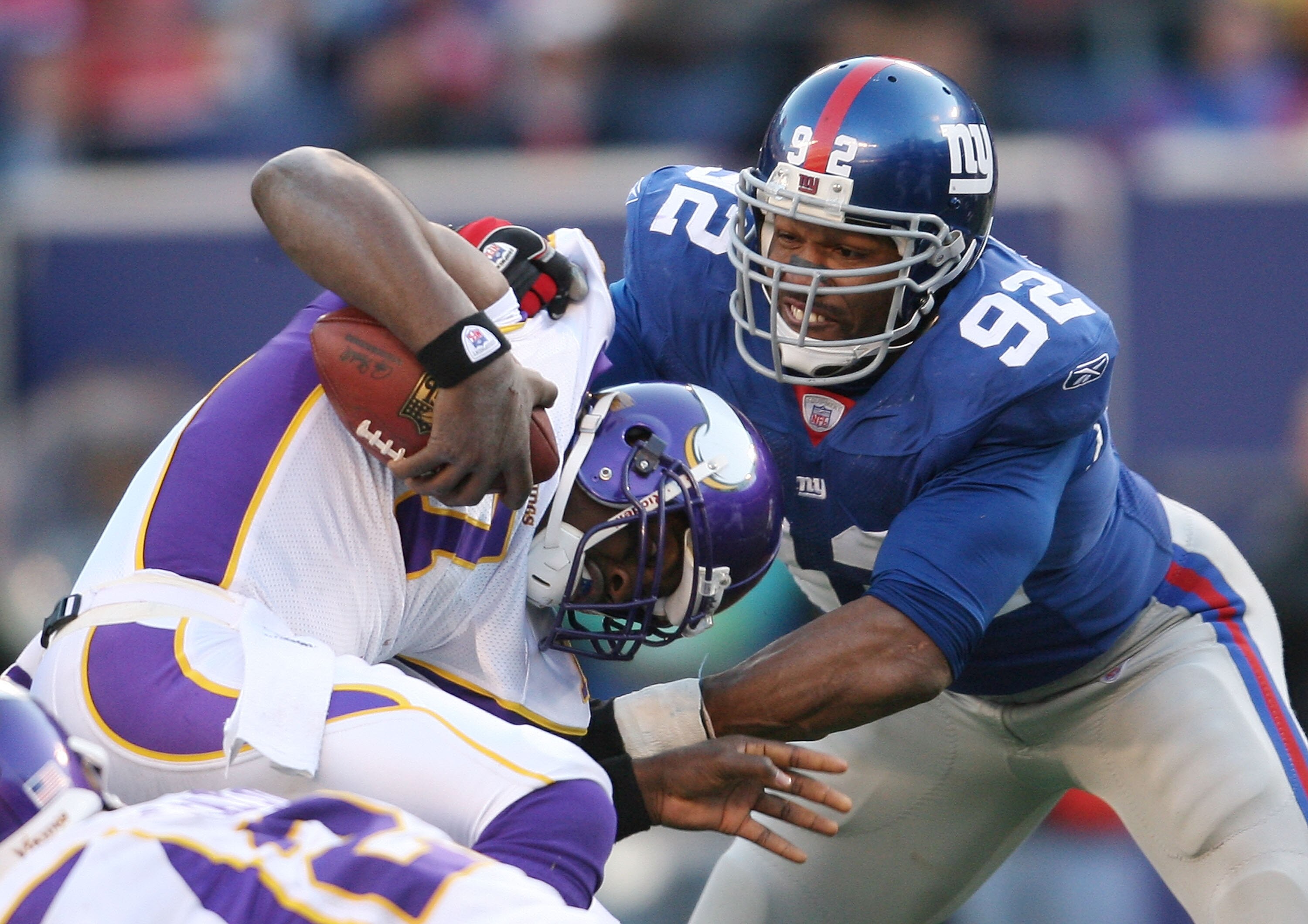 EAST RUTHERFORD, NJ - NOVEMBER 25:  Tarvaris Jackson #7 of the Minnesota Vikings is tackled by Michael Strahan #92 of the New York Giants at Giants Stadium on November 25, 2007 in East Rutherford, New Jersey.  (Photo by Nick Laham/Getty Images)