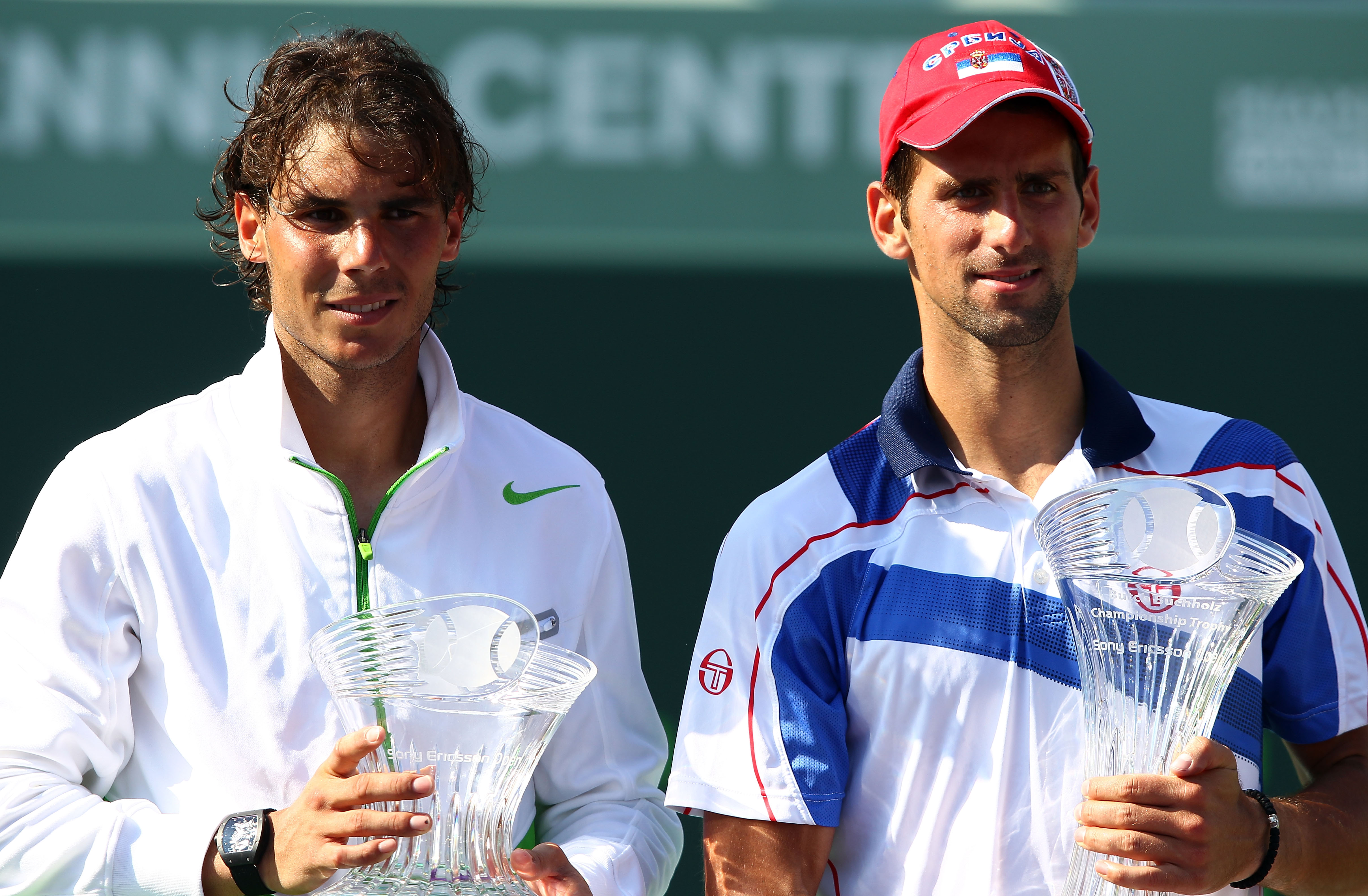 KEY BISCAYNE, FL - APRIL 03:  Novak Djokovic of Serbia celebrates with the trophy as Rafael Nadal (L) of Spain looks on holding the runner up trophy after Djokovic won the men's singles championship at the Sony Ericsson Open at Crandon Park Tennis Center